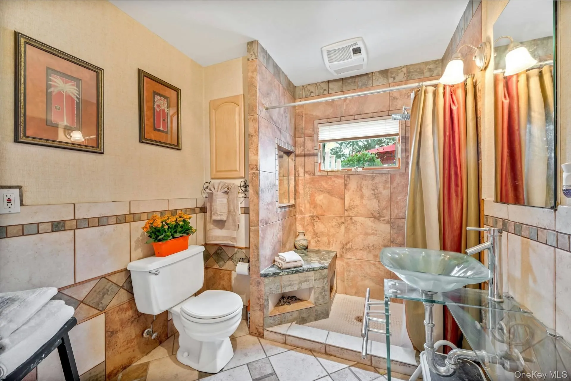 Full bathroom featuring tile walls, a stall shower, and tile patterned flooring Full bathroom featuring tile walls, a stall shower, and tile patterned flooring