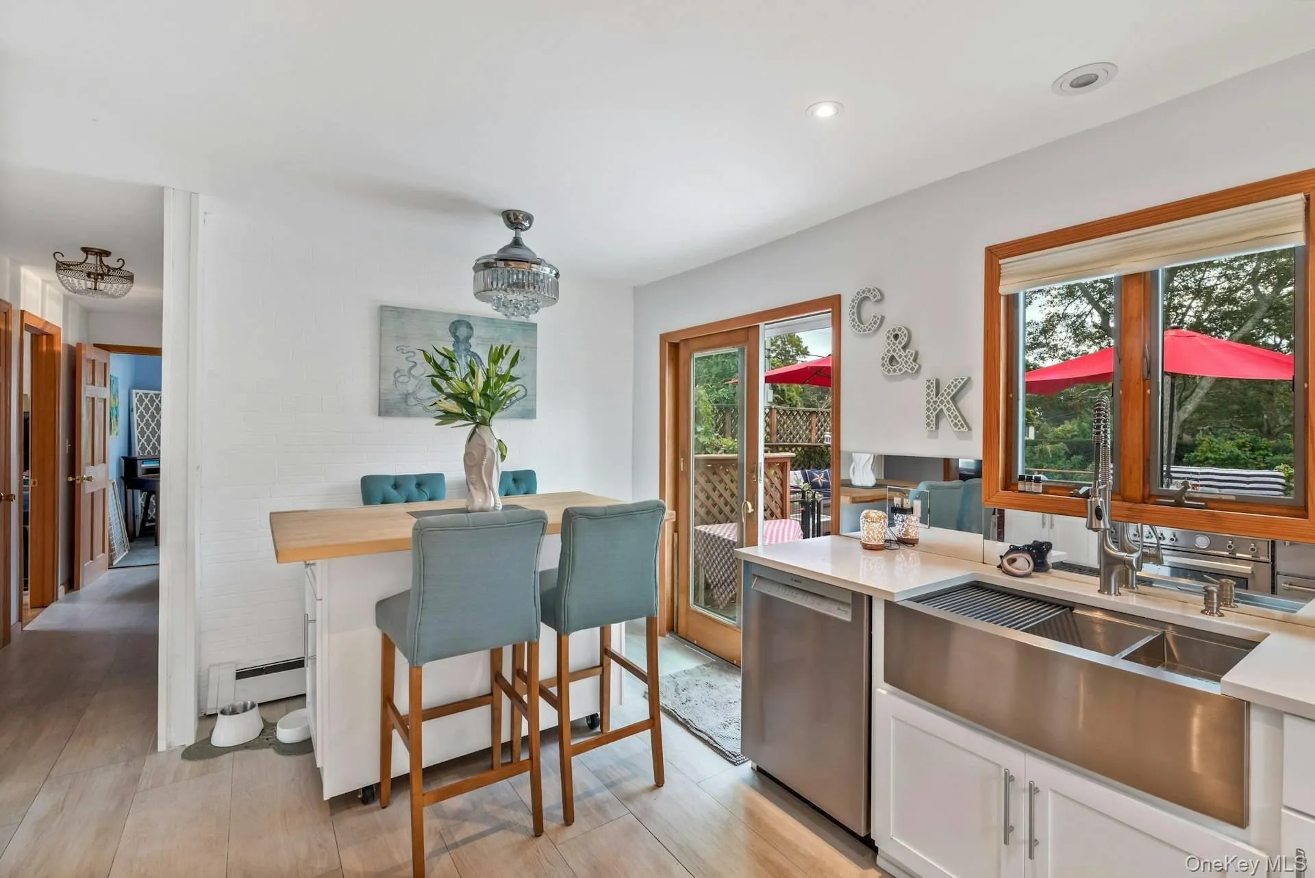 Kitchen with dishwasher, white cabinetry, a baseboard heating unit, light wood finished floors, and recessed lighting Kitchen with dishwasher, white cabinetry, a baseboard heating unit, light wood finished floors, and recessed lighting