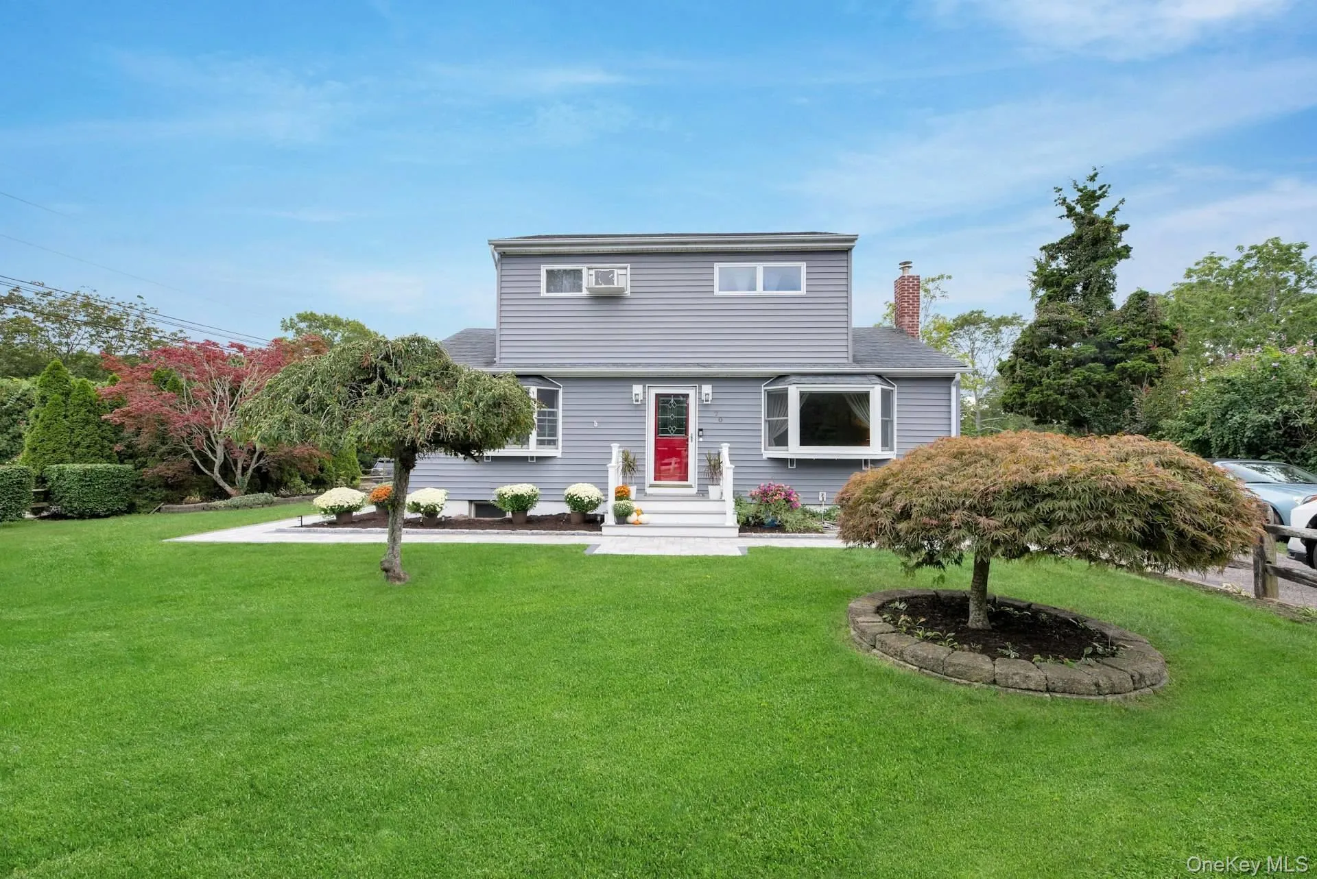 Colonial-style house with a front yard and a chimney Colonial-style house with a front yard and a chimney