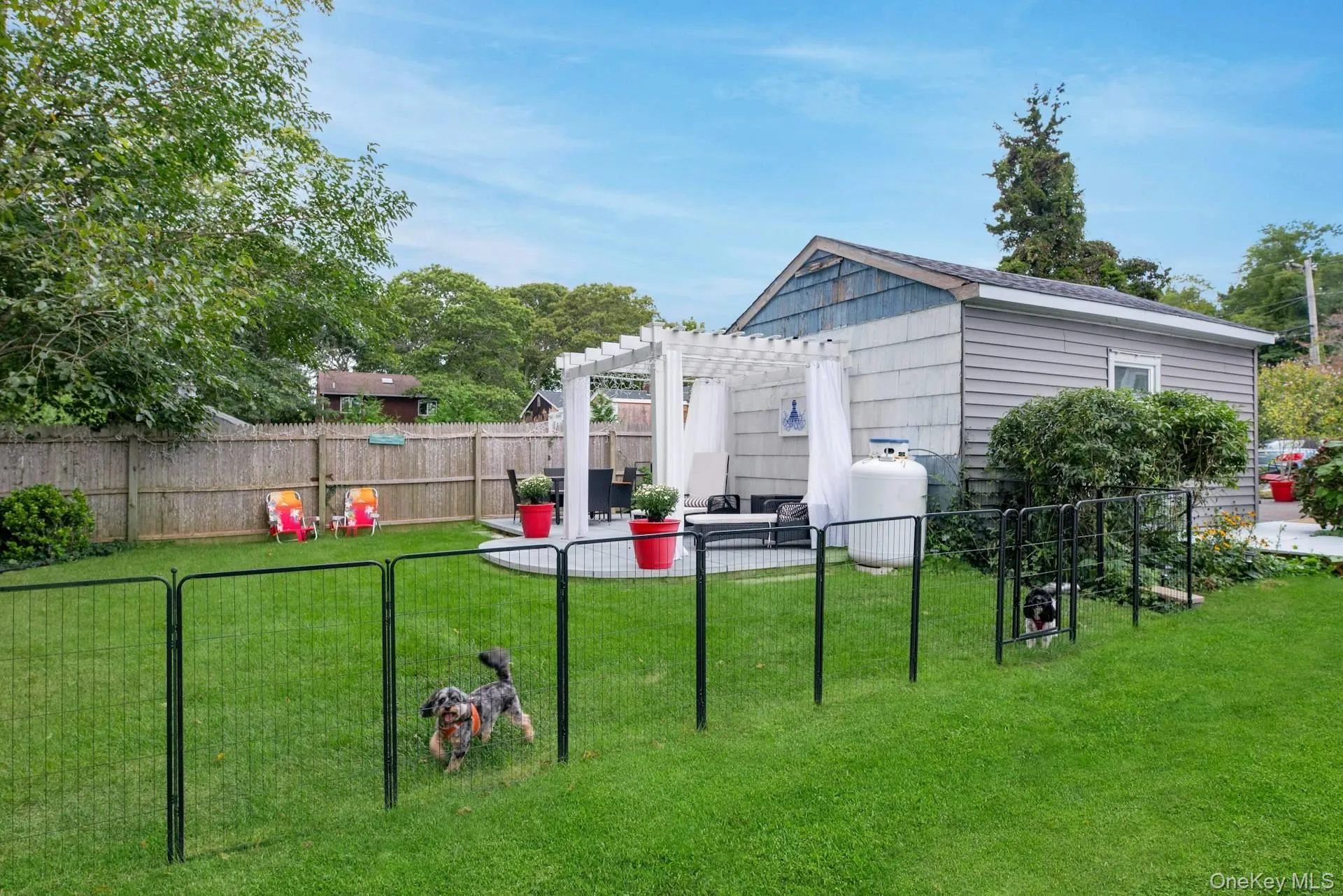 Fenced backyard with a patio area and a pergola Fenced backyard with a patio area and a pergola