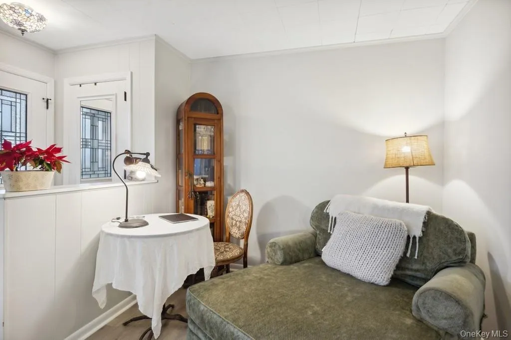 Living area featuring ornamental molding and wood finished floors Living area featuring ornamental molding and wood finished floors