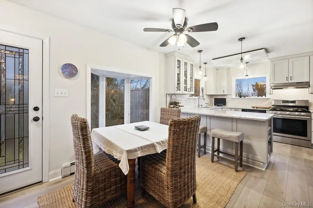 Dining space with light wood-style flooring, healthy amount of natural light, a ceiling fan, and a baseboard radiator Dining space with light wood-style flooring, healthy amount of natural light, a ceiling fan, and a baseboard radiator