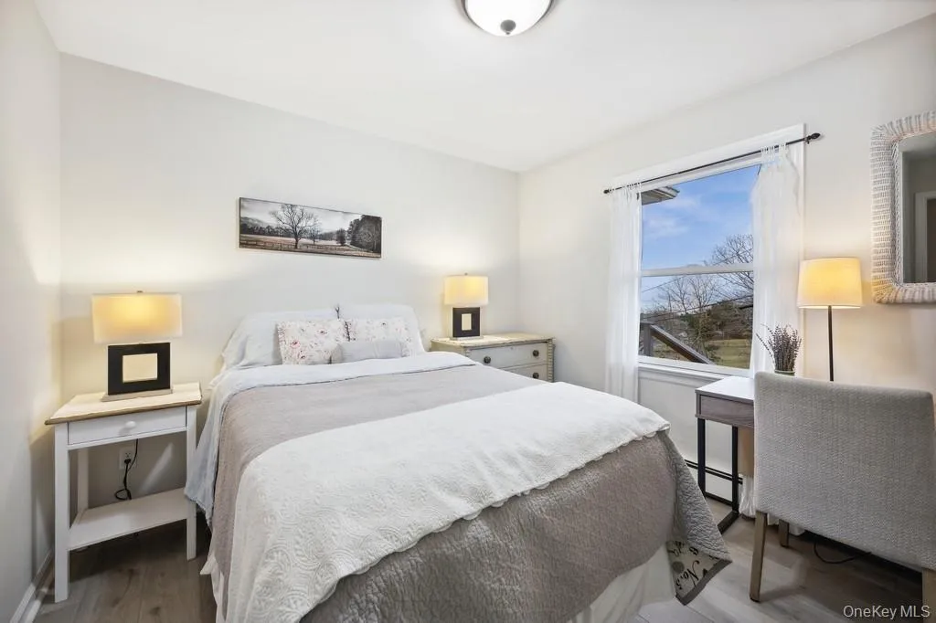 Bedroom featuring wood finished floors and a baseboard radiator Bedroom featuring wood finished floors and a baseboard radiator