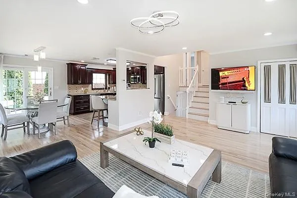 Living area featuring stairway, light wood finished floors, recessed lighting, and ornamental molding Living area featuring stairway, light wood finished floors, recessed lighting, and ornamental molding