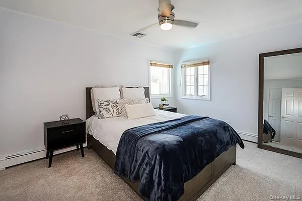 Carpeted bedroom with a ceiling fan Carpeted bedroom with a ceiling fan