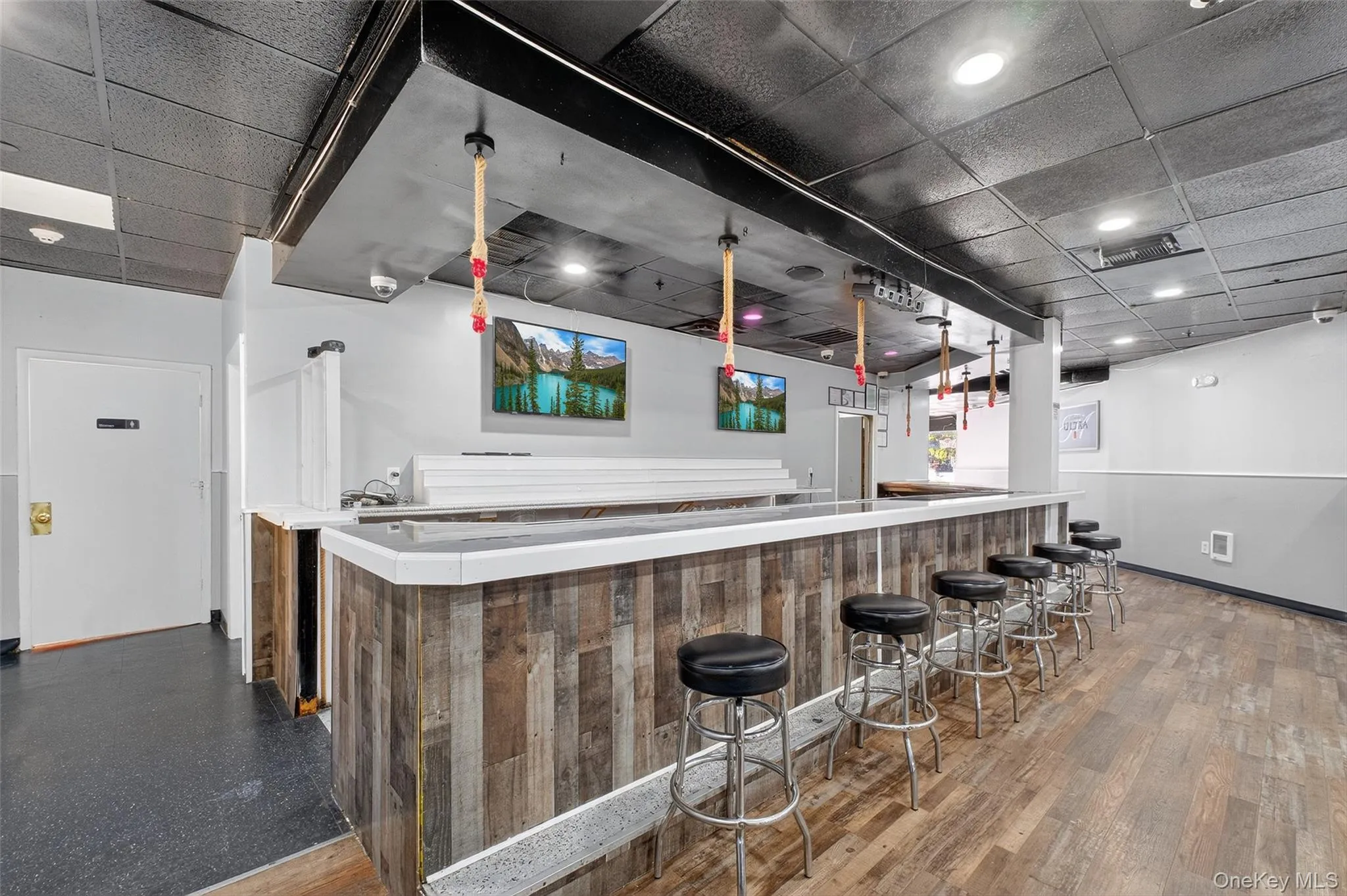 Indoor wet bar featuring a paneled ceiling and light countertops Indoor wet bar featuring a paneled ceiling and light countertops