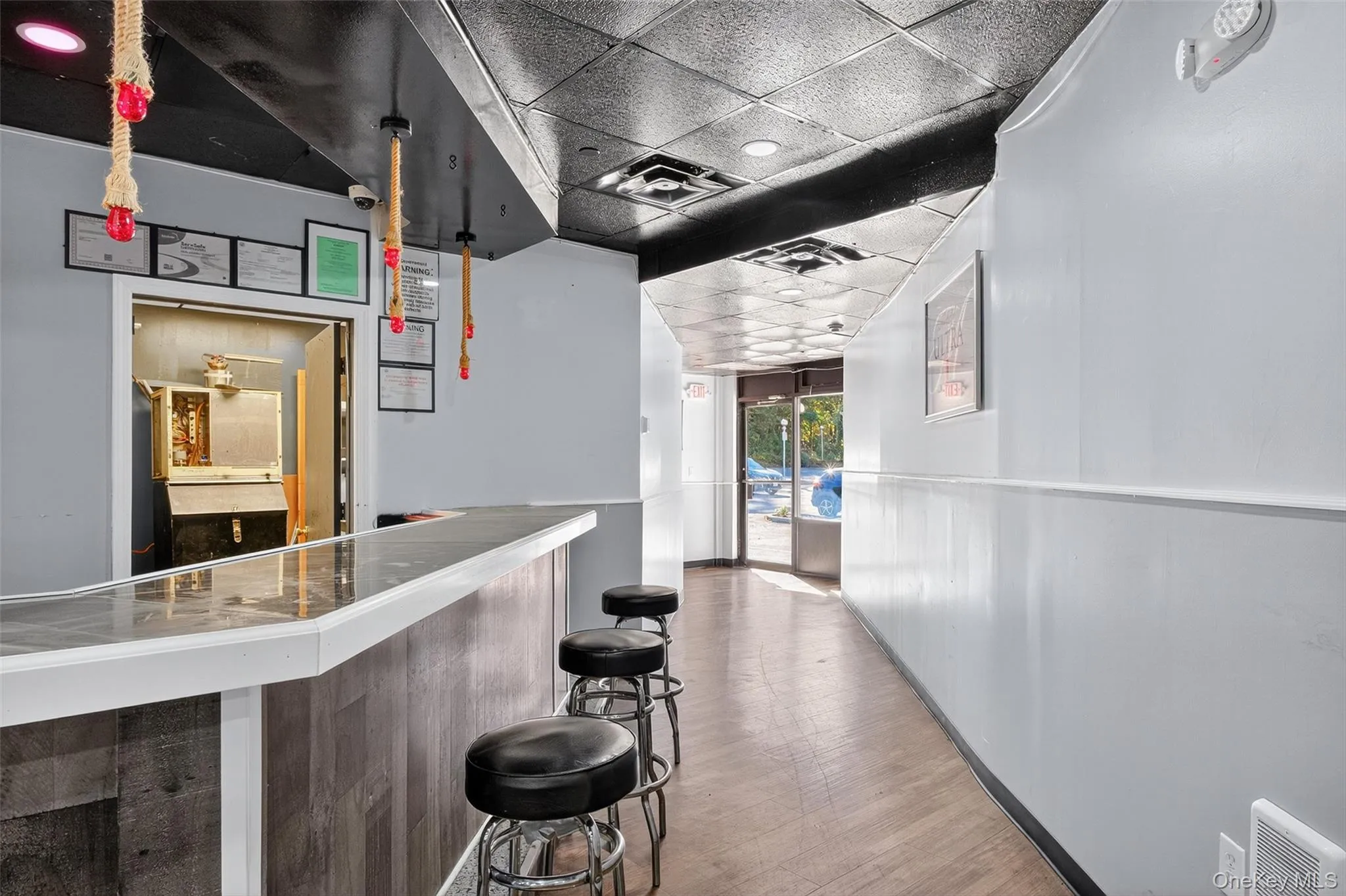 Reception area with a paneled ceiling, a bar, and a wainscoted wall Reception area with a paneled ceiling, a bar, and a wainscoted wall