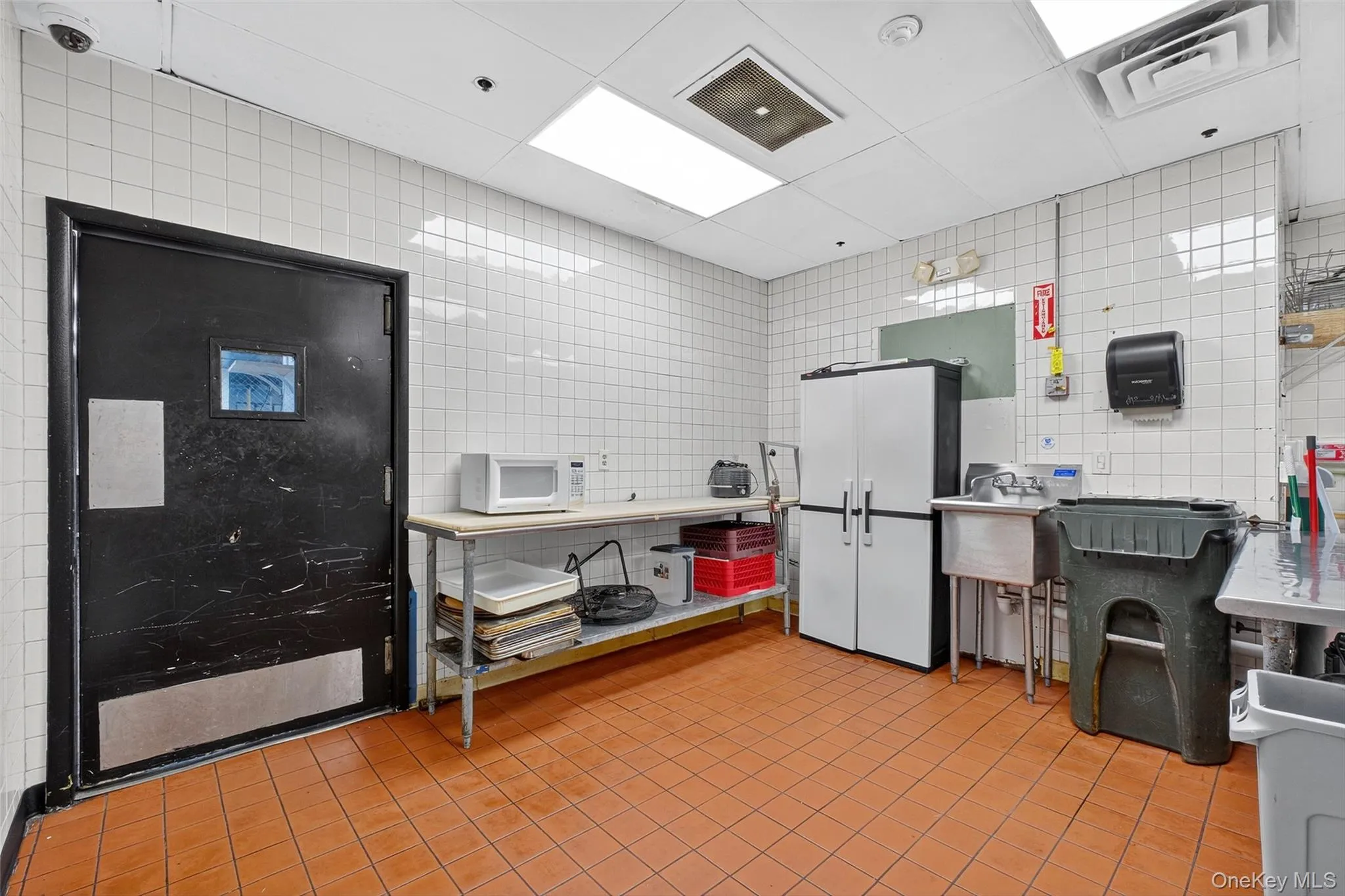 Kitchen with tile walls and white microwave Kitchen with tile walls and white microwave