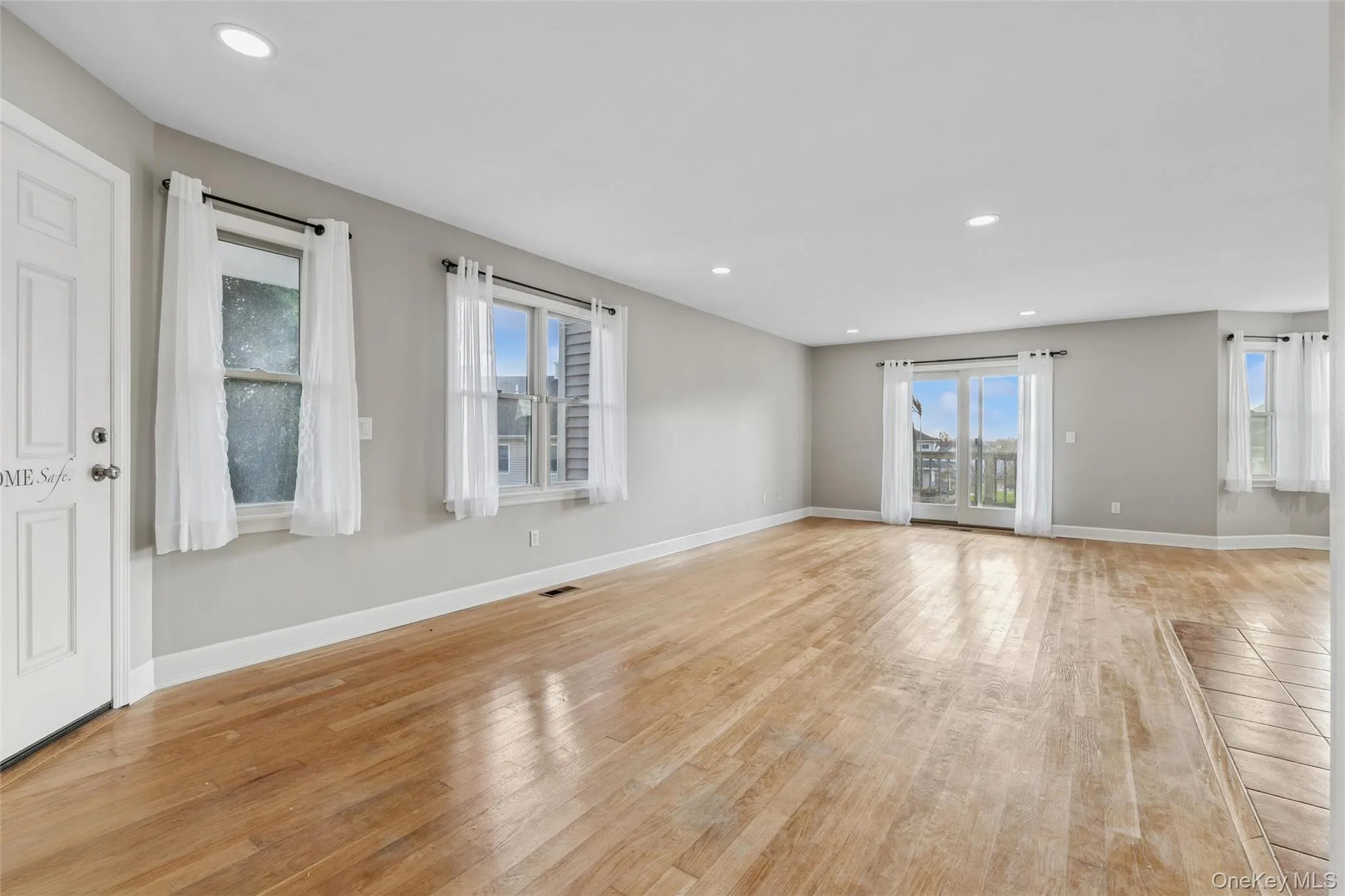 Unfurnished living room featuring plenty of natural light, recessed lighting, and light wood-style flooring Unfurnished living room featuring plenty of natural light, recessed lighting, and light wood-style flooring
