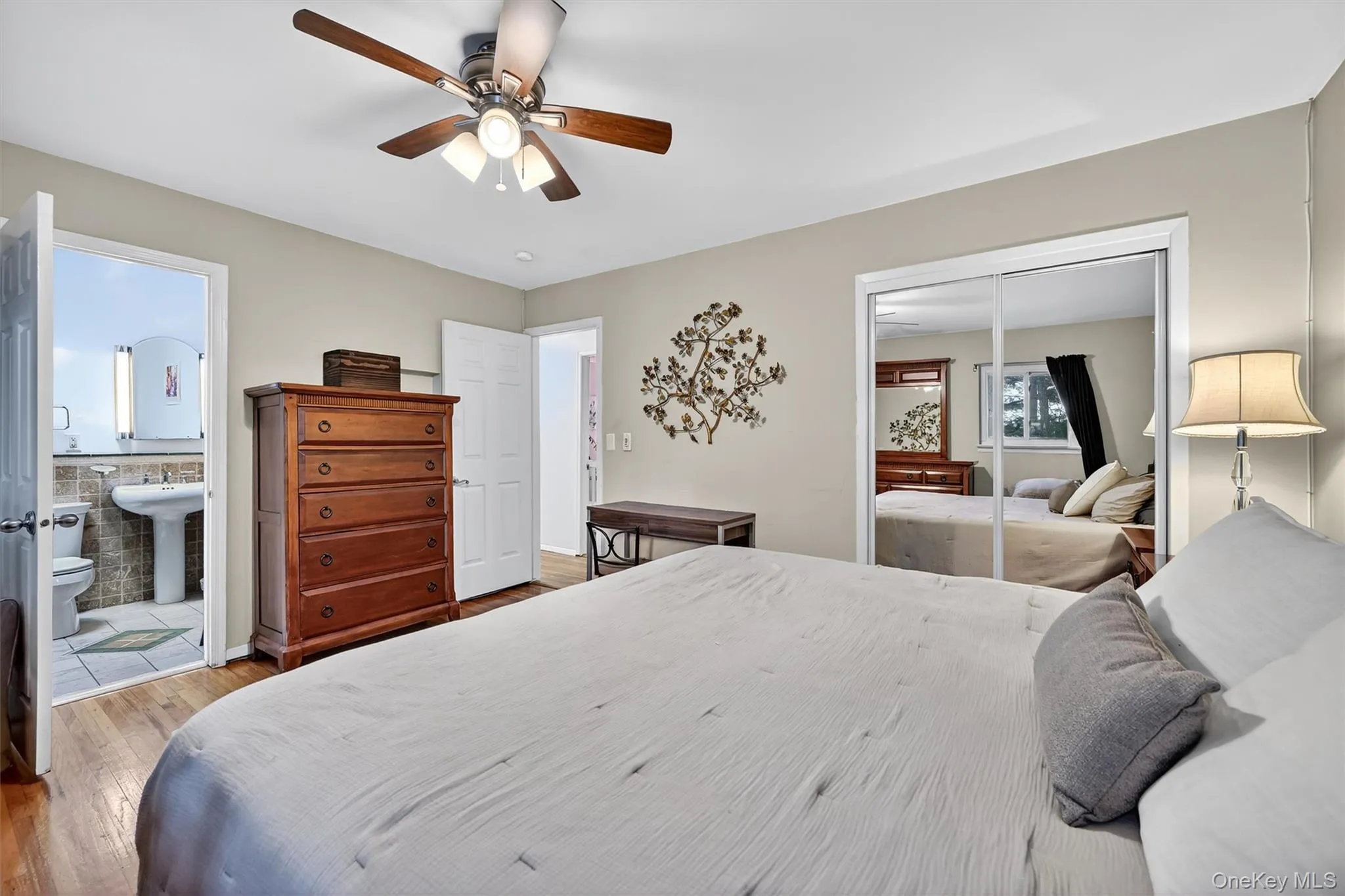 Bedroom with a closet, wood finished floors, ceiling fan, and ensuite bathroom Bedroom with a closet, wood finished floors, ceiling fan, and ensuite bathroom