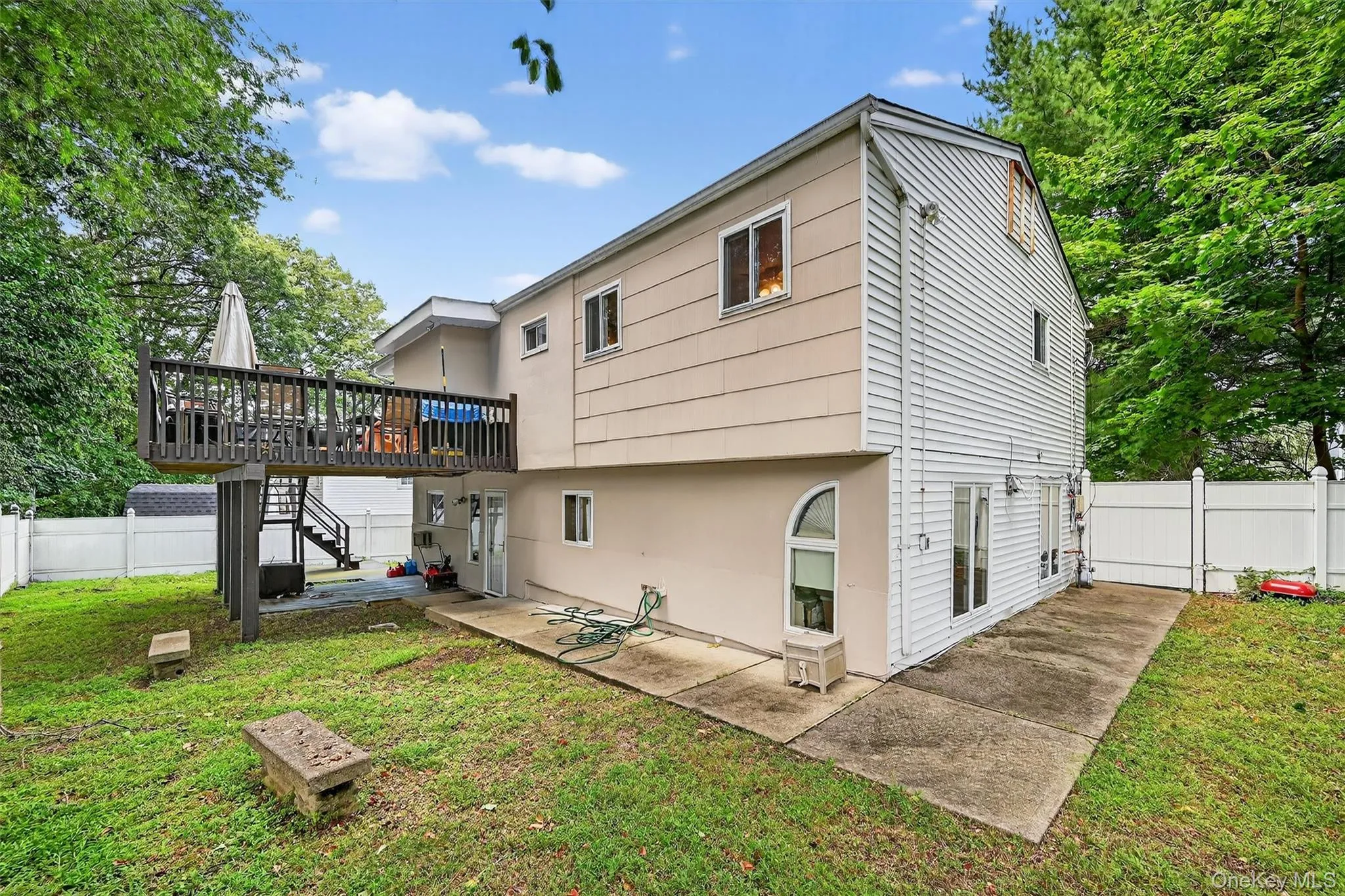 Back of house featuring a patio, a deck, stairs, and stucco siding Back of house featuring a patio, a deck, stairs, and stucco siding