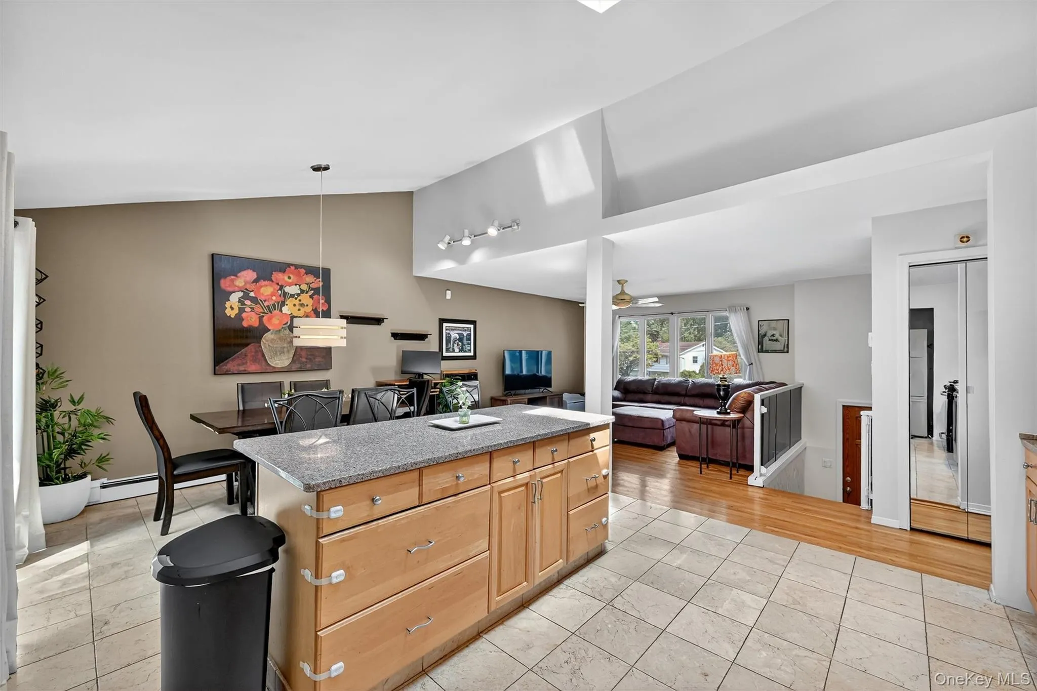 Kitchen with vaulted ceiling, a center island, dark stone countertops, open floor plan, and pendant lighting Kitchen with vaulted ceiling, a center island, dark stone countertops, open floor plan, and pendant lighting