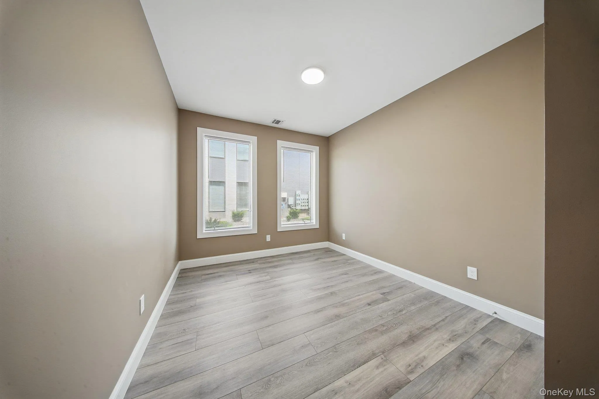 Unfurnished room with light wood-style flooring and baseboards Unfurnished room with light wood-style flooring and baseboards
