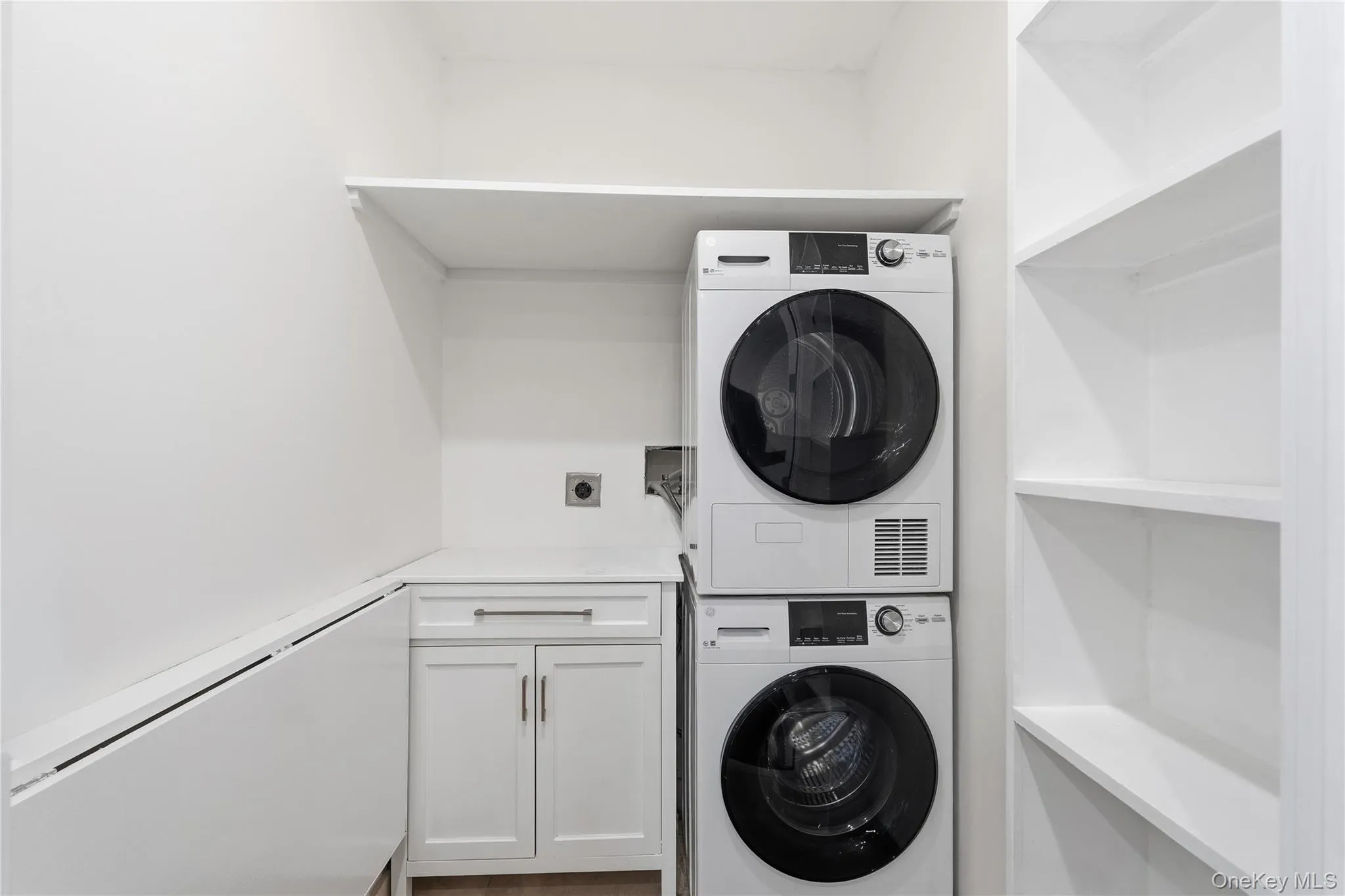 Laundry room with stacked washing machine and dryer and cabinet space Laundry room with stacked washing machine and dryer and cabinet space