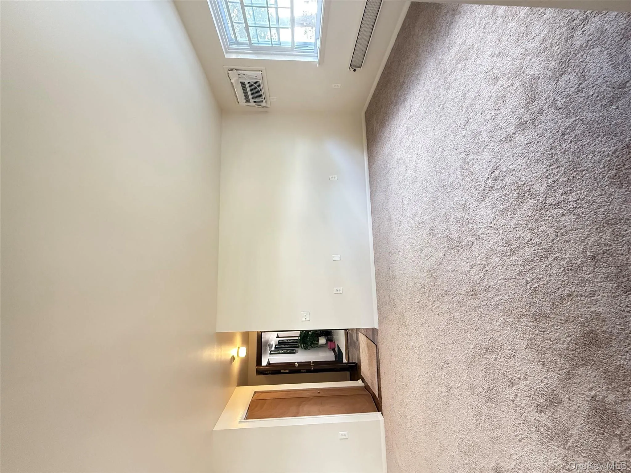 Unfurnished room featuring light colored carpet and an AC wall unit Unfurnished room featuring light colored carpet and an AC wall unit