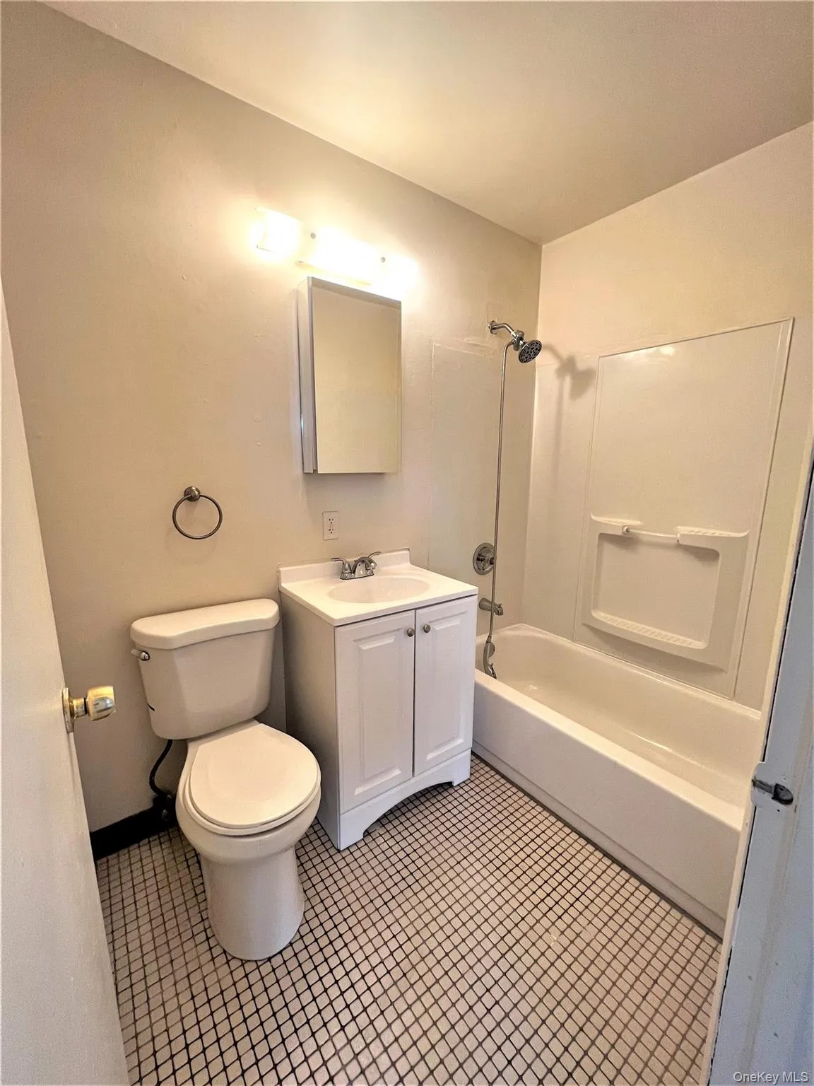 Full bath featuring vanity, washtub / shower combination, and light tile patterned flooring Full bath featuring vanity, washtub / shower combination, and light tile patterned flooring