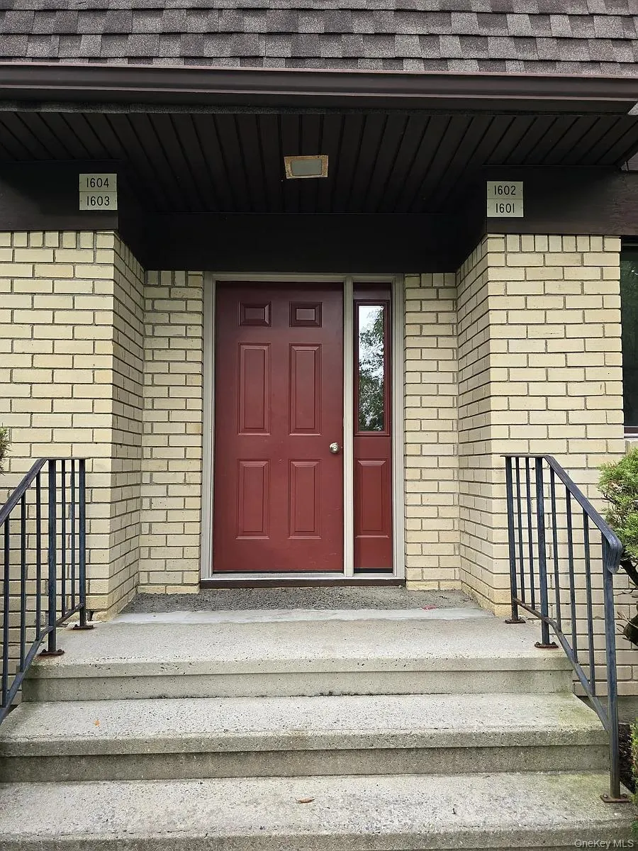View of exterior entry featuring a shingled roof, brick siding, and a porch View of exterior entry featuring a shingled roof, brick siding, and a porch