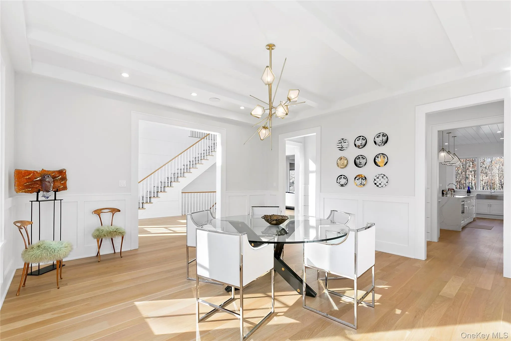 Dining space with a chandelier, light wood-style floors, a decorative wall, wainscoting, and beam ceiling Dining space with a chandelier, light wood-style floors, a decorative wall, wainscoting, and beam ceiling