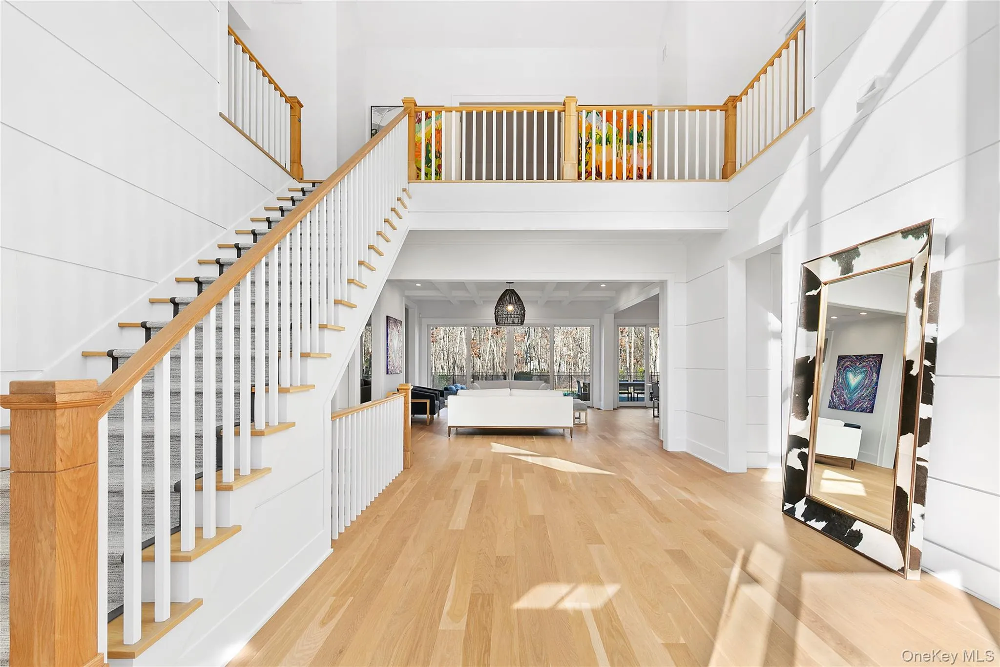 Entryway with wood finished floors, a towering ceiling, and stairs Entryway with wood finished floors, a towering ceiling, and stairs