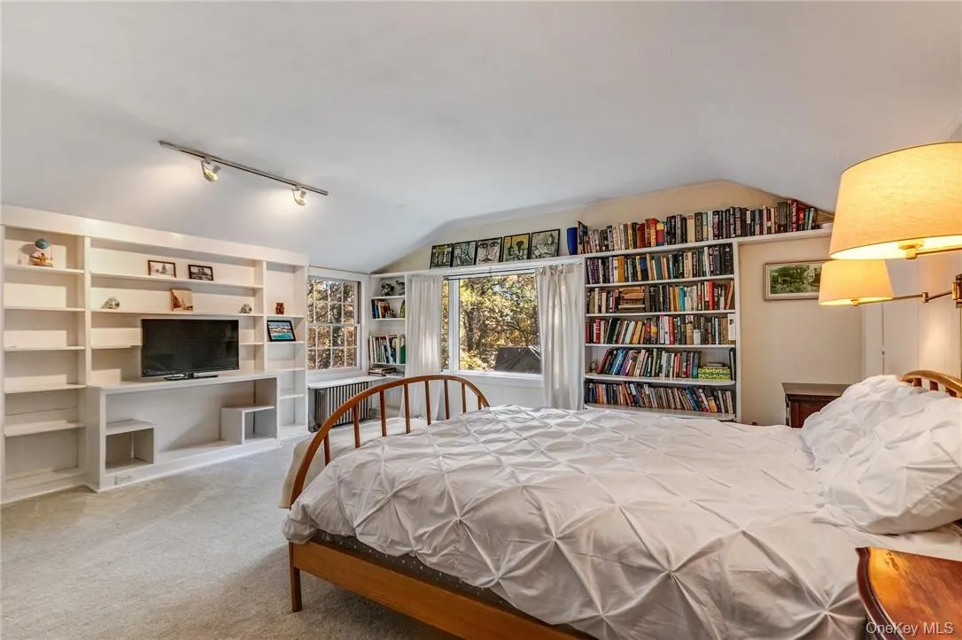 Upper level, bedroom featuring track lighting and vaulted ceiling Upper level, bedroom featuring track lighting and vaulted ceiling