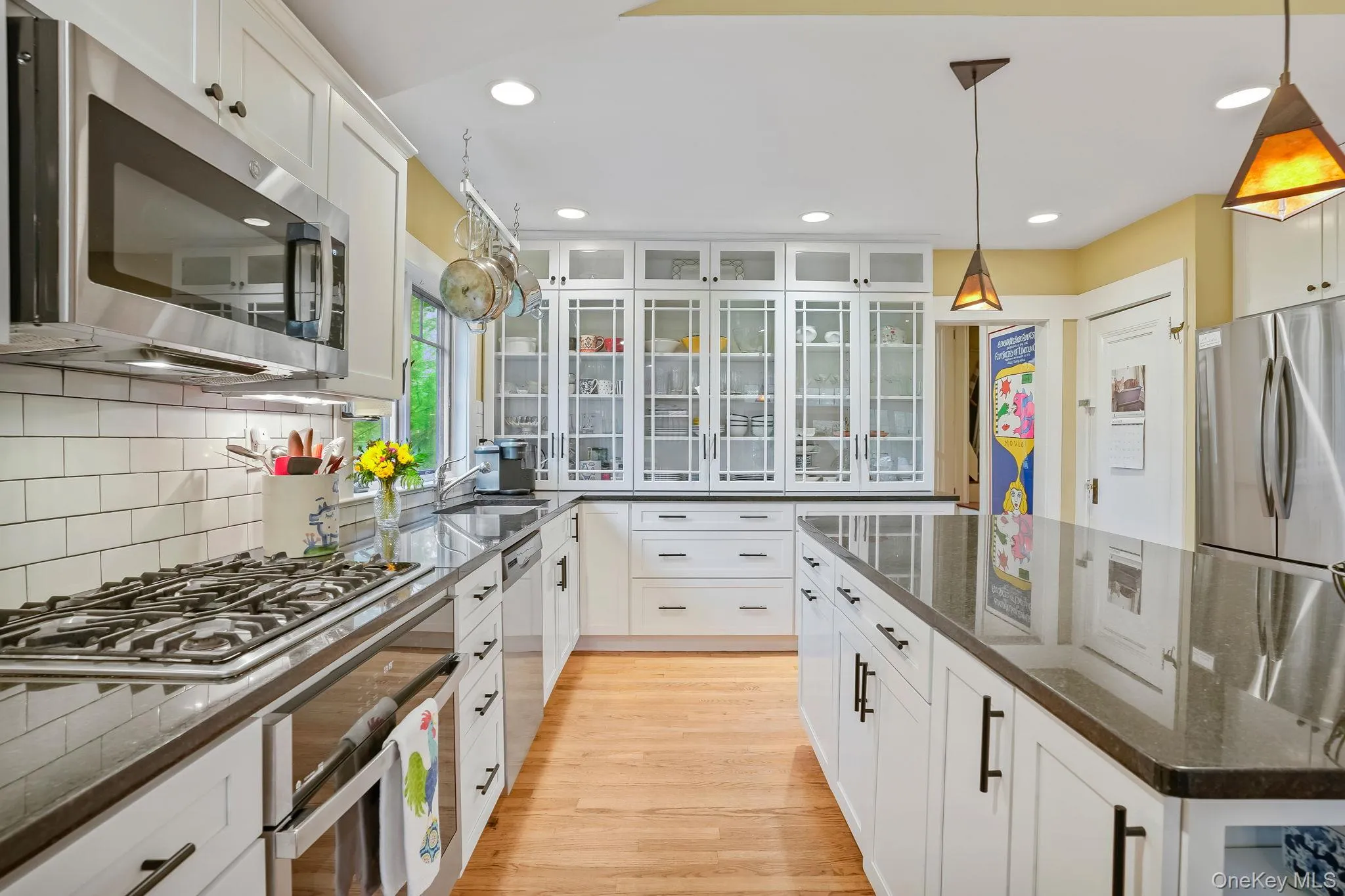 Kitchen with white cabinets, stainless steel appliances, stone countertops, pendant lighting, and recessed lighting Kitchen with white cabinets, stainless steel appliances, stone countertops, pendant lighting, and recessed lighting