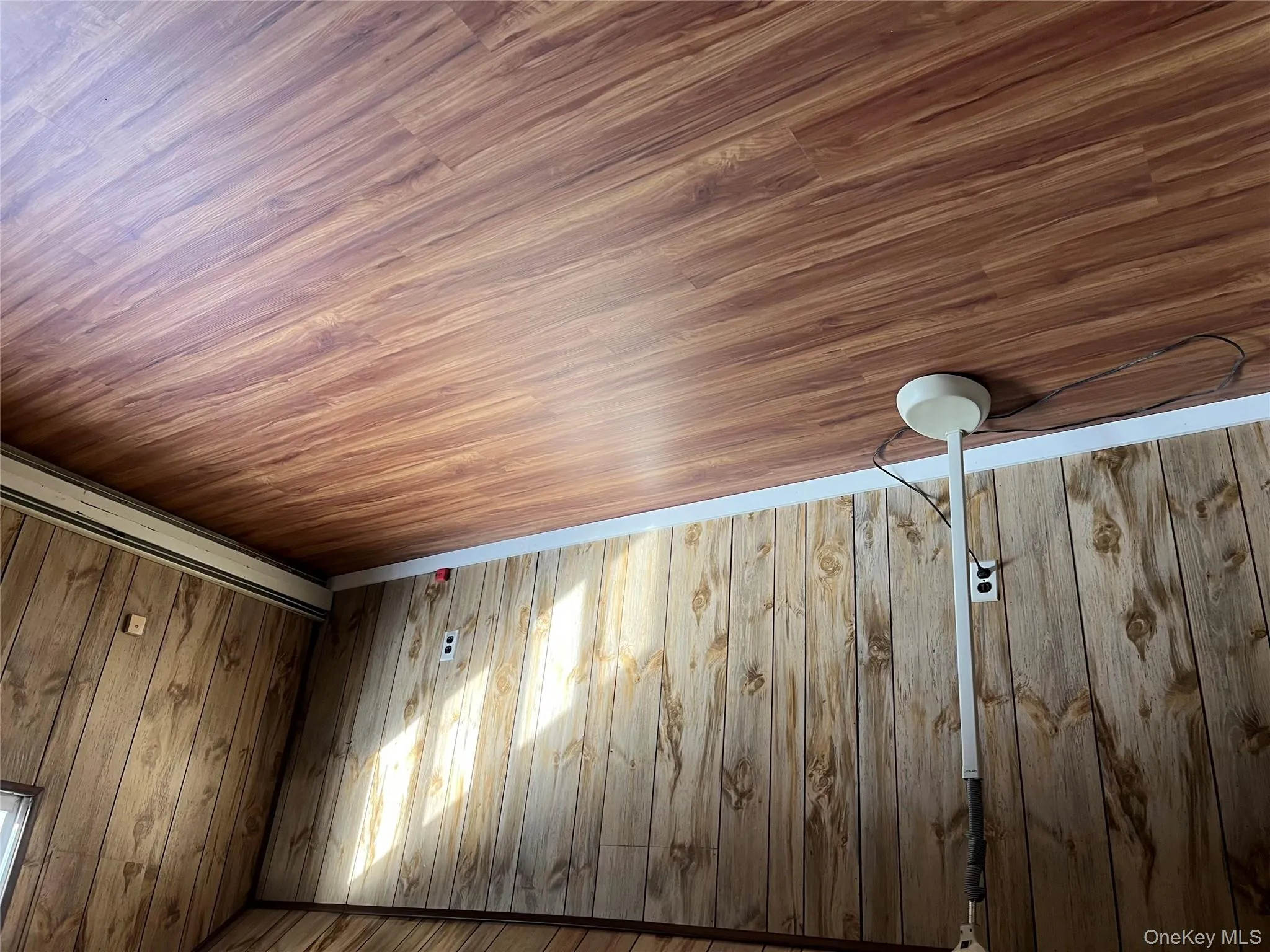 Unfurnished room with wood finished floors and wood walls Unfurnished room with wood finished floors and wood walls