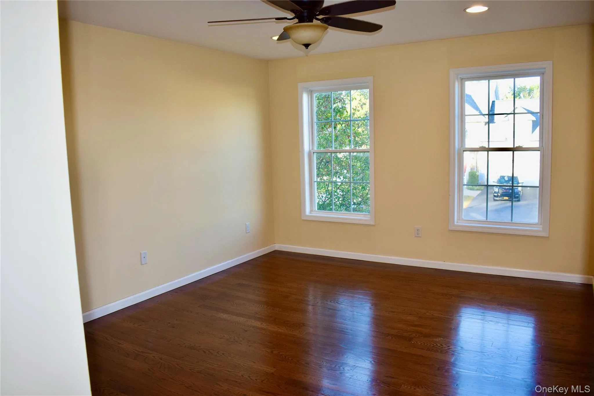 Empty room with dark wood finished floors, recessed lighting, and ceiling fan Empty room with dark wood finished floors, recessed lighting, and ceiling fan