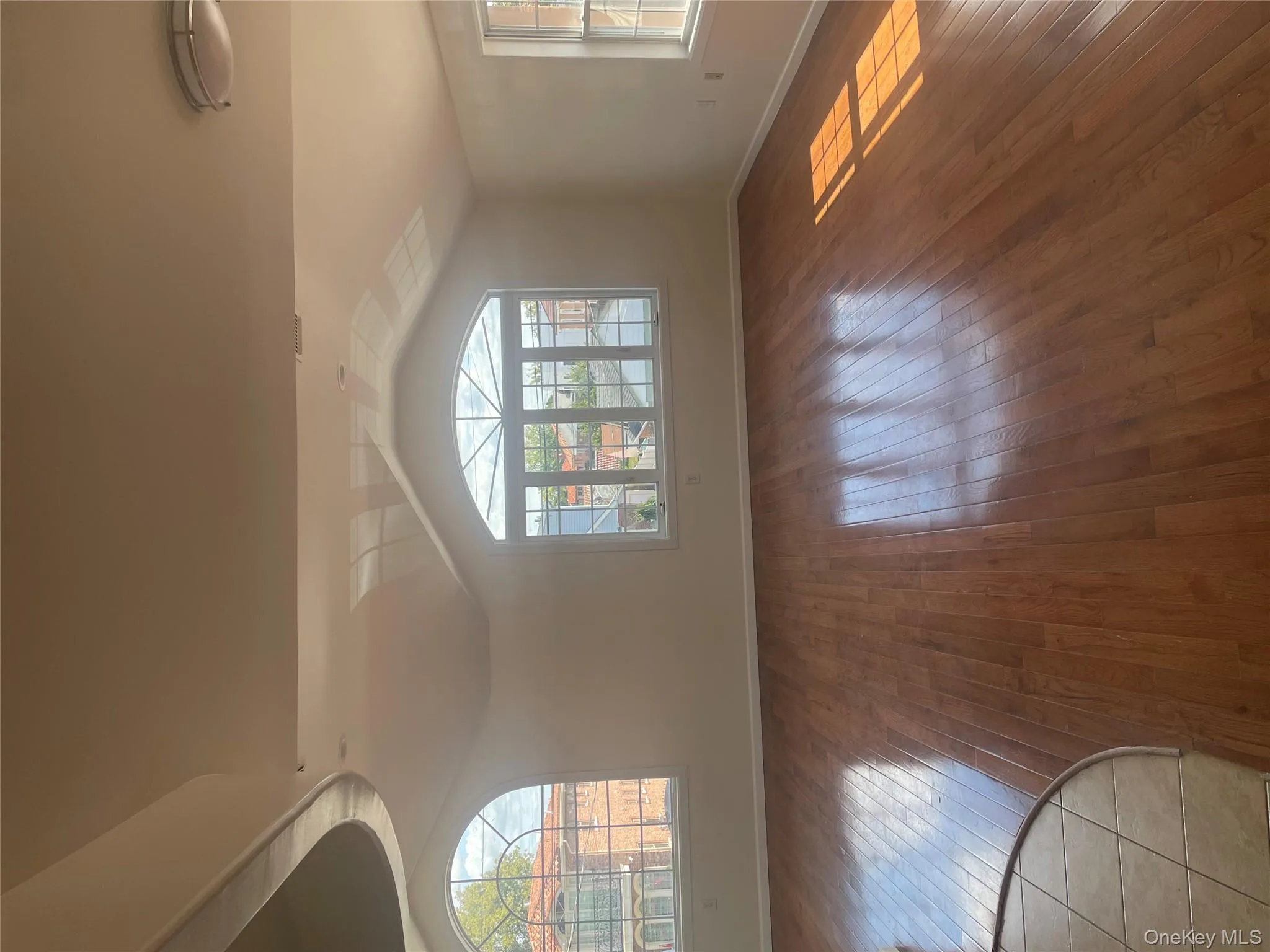 Empty room featuring lofted ceiling and hardwood / wood-style floors Empty room featuring lofted ceiling and hardwood / wood-style floors