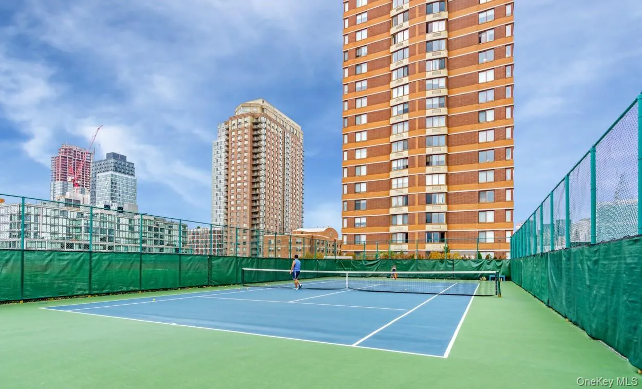 View of tennis court with a city view and community basketball court View of tennis court with a city view and community basketball court