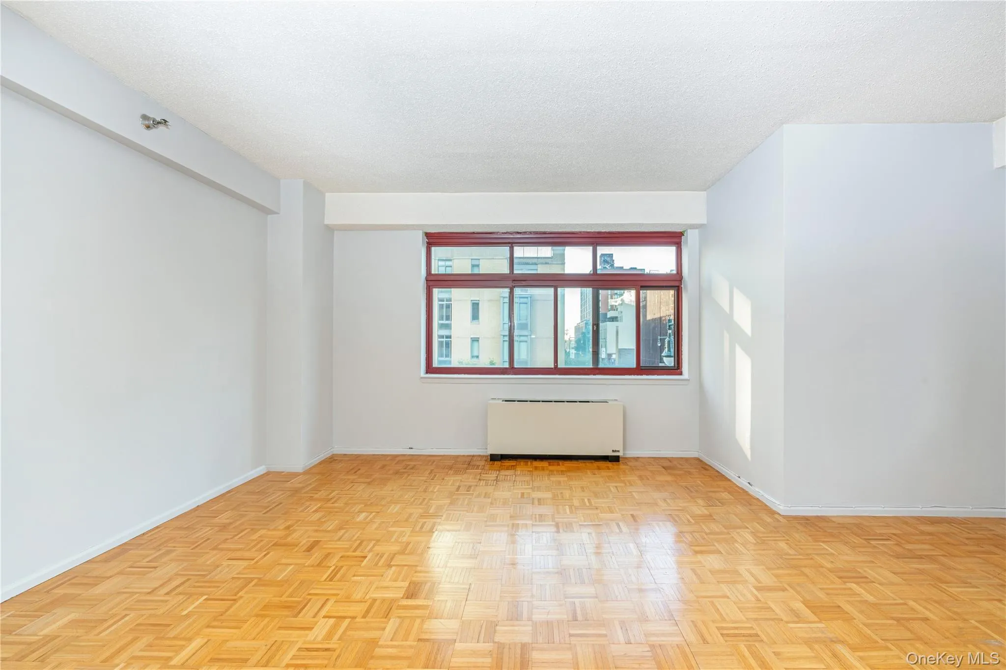 Empty room with radiator heating unit and a textured ceiling Empty room with radiator heating unit and a textured ceiling
