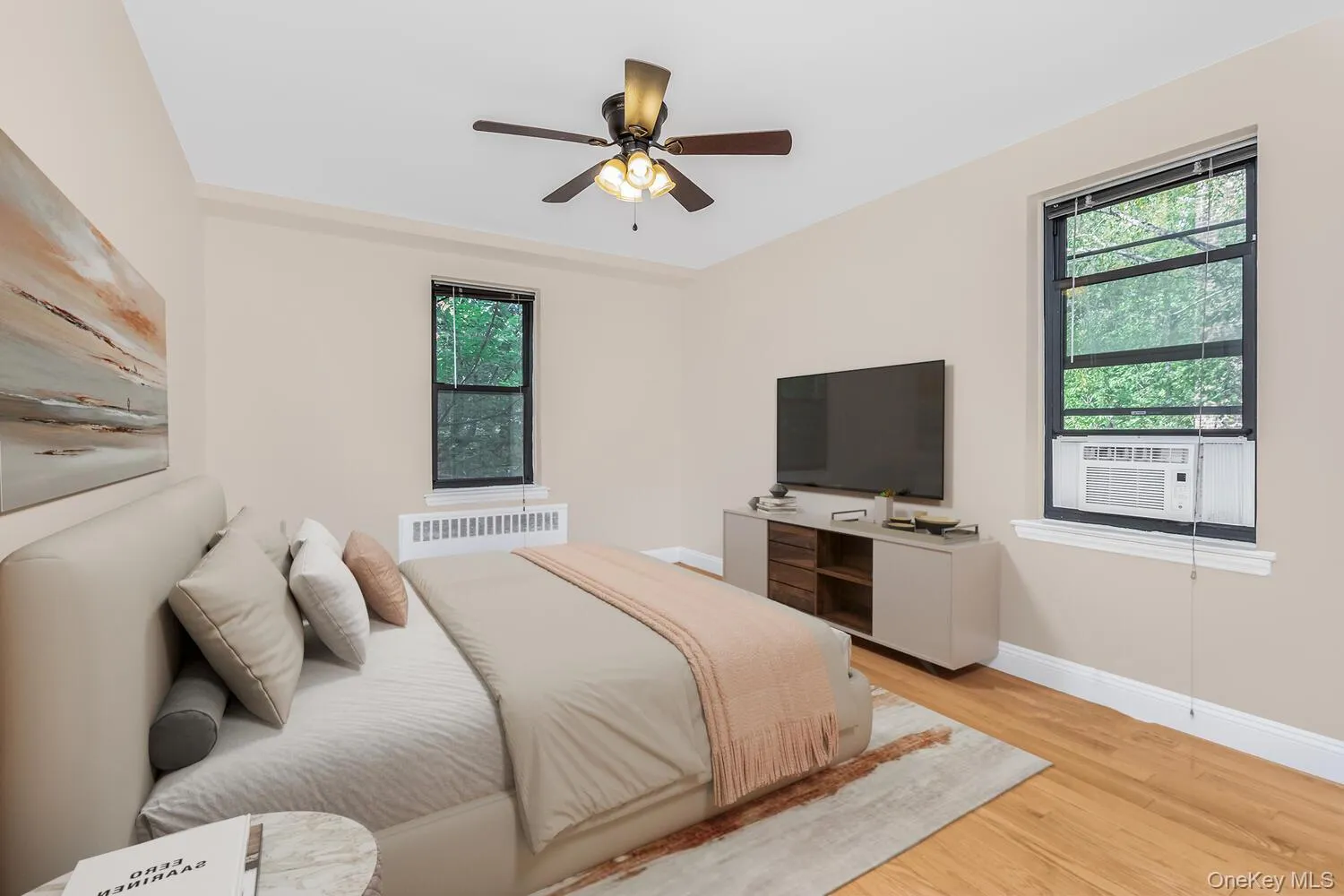 Bedroom with light wood-type flooring, ceiling fan, radiator heating unit, and cooling unit Bedroom with light wood-type flooring, ceiling fan, radiator heating unit, and cooling unit