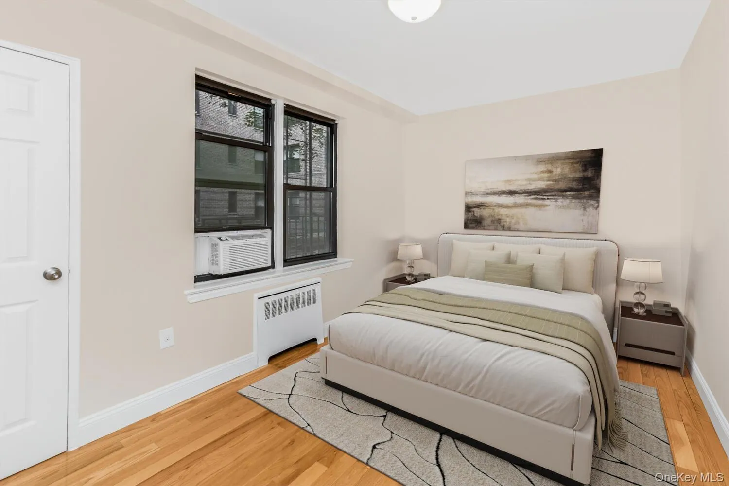 Bedroom featuring radiator heating unit, light wood-style floors, and cooling unit Bedroom featuring radiator heating unit, light wood-style floors, and cooling unit