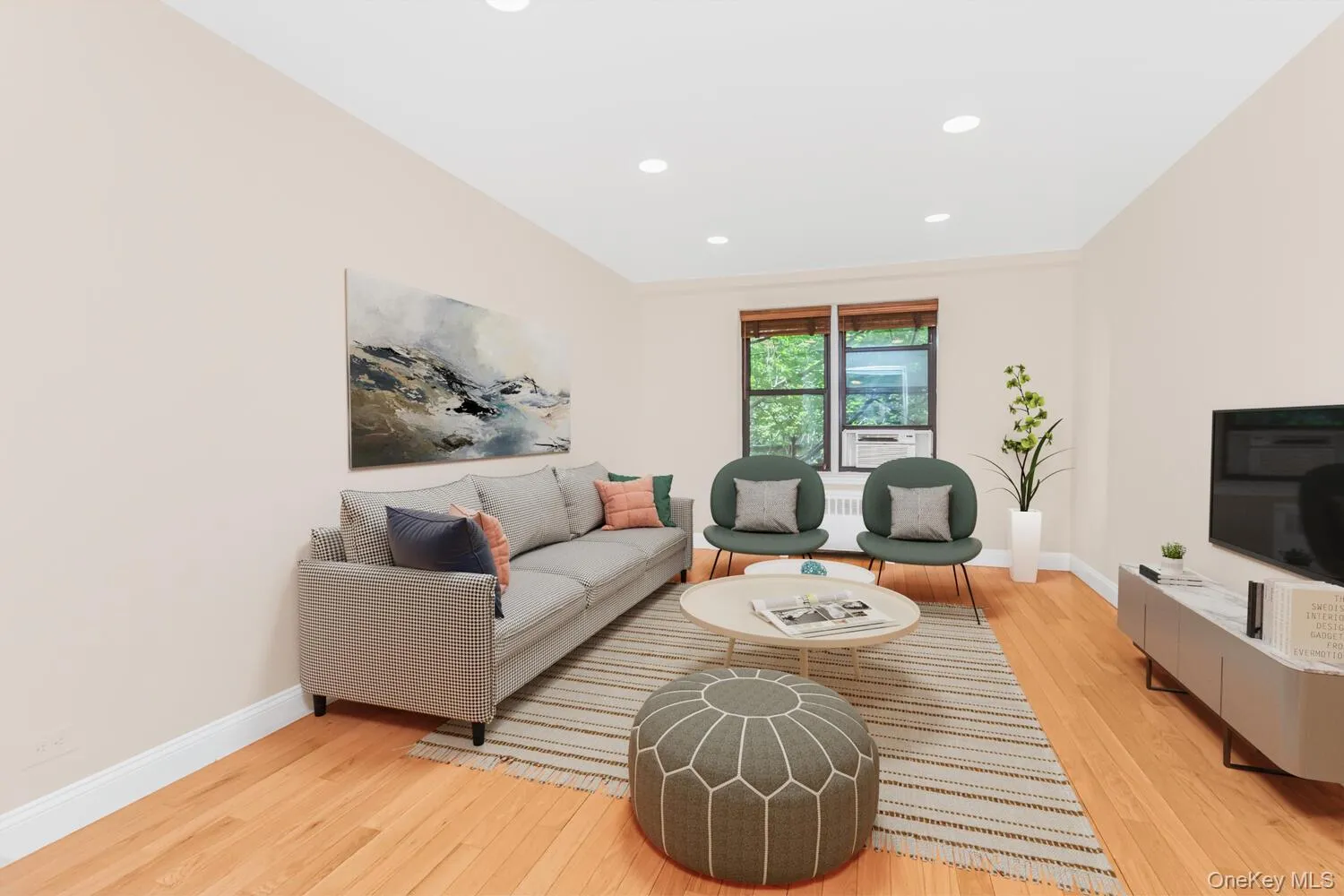 Living area featuring light wood finished floors, recessed lighting, and radiator Living area featuring light wood finished floors, recessed lighting, and radiator
