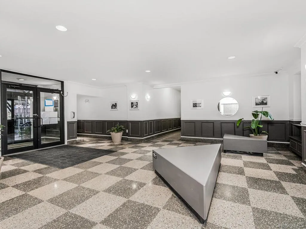 Building lobby featuring a decorative wall, a wainscoted wall, and recessed lighting Building lobby featuring a decorative wall, a wainscoted wall, and recessed lighting
