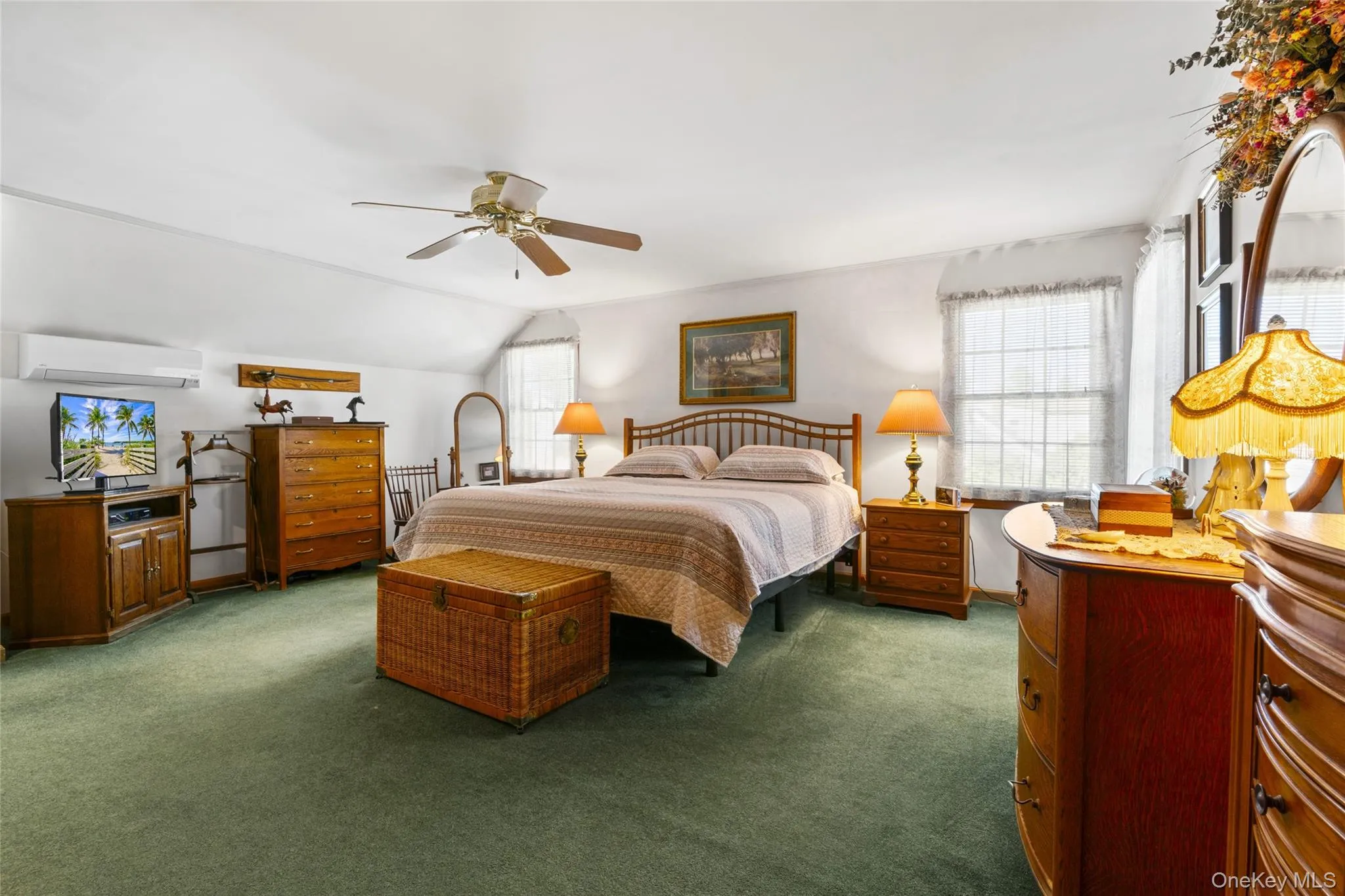 Bedroom featuring multiple windows, carpet, ceiling fan, and an AC wall unit Bedroom featuring multiple windows, carpet, ceiling fan, and an AC wall unit