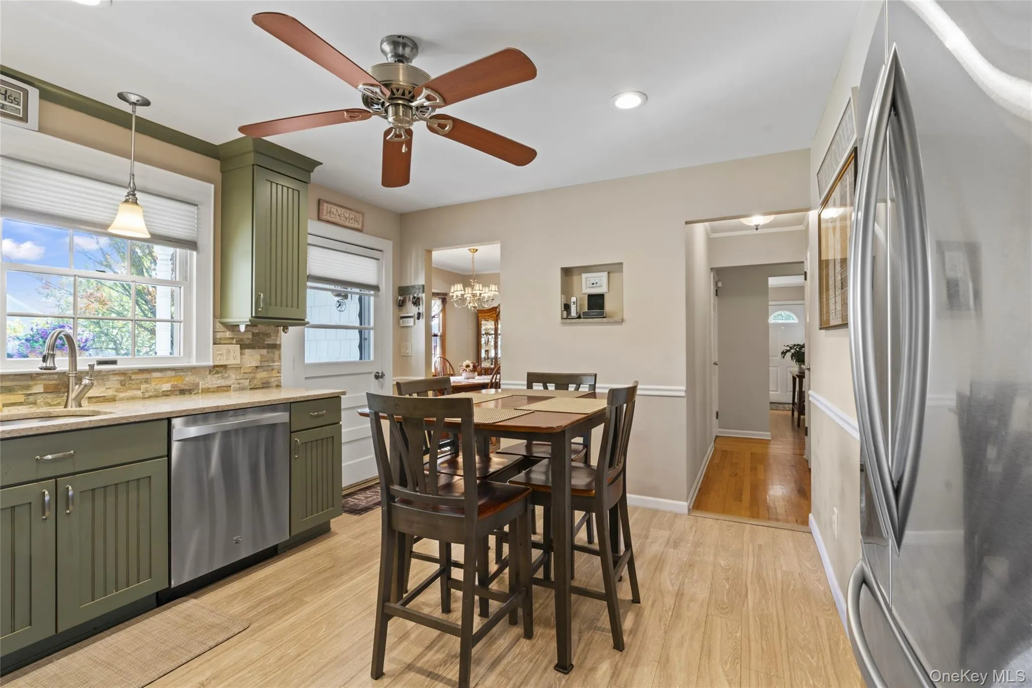 Kitchen featuring green cabinetry, stainless steel appliances, light wood-style floors, light stone counters, and recessed lighting Kitchen featuring green cabinetry, stainless steel appliances, light wood-style floors, light stone counters, and recessed lighting