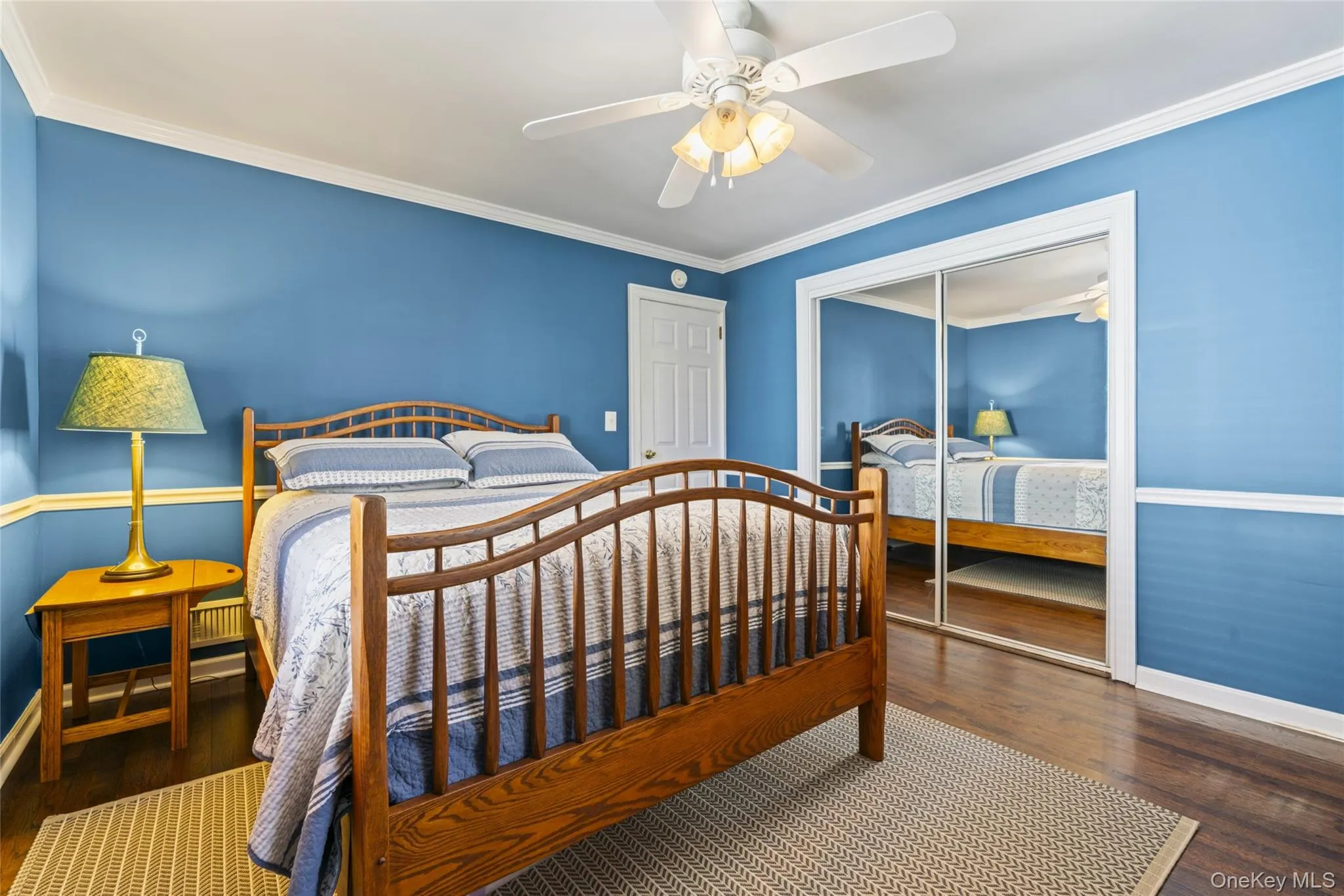 Bedroom featuring dark wood finished floors, crown molding, a closet, and ceiling fan Bedroom featuring dark wood finished floors, crown molding, a closet, and ceiling fan