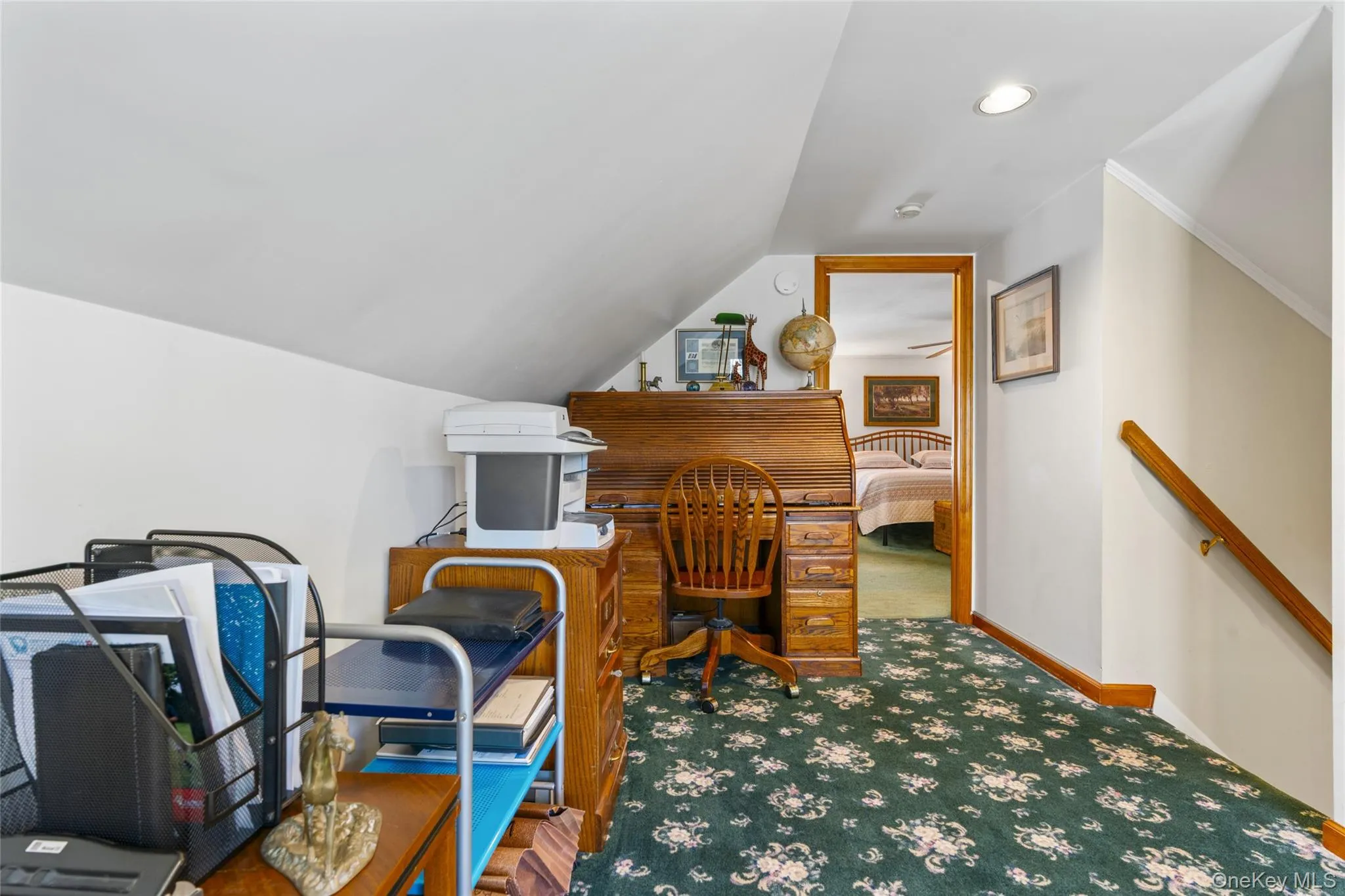 Carpeted office space with vaulted ceiling and baseboards Carpeted office space with vaulted ceiling and baseboards