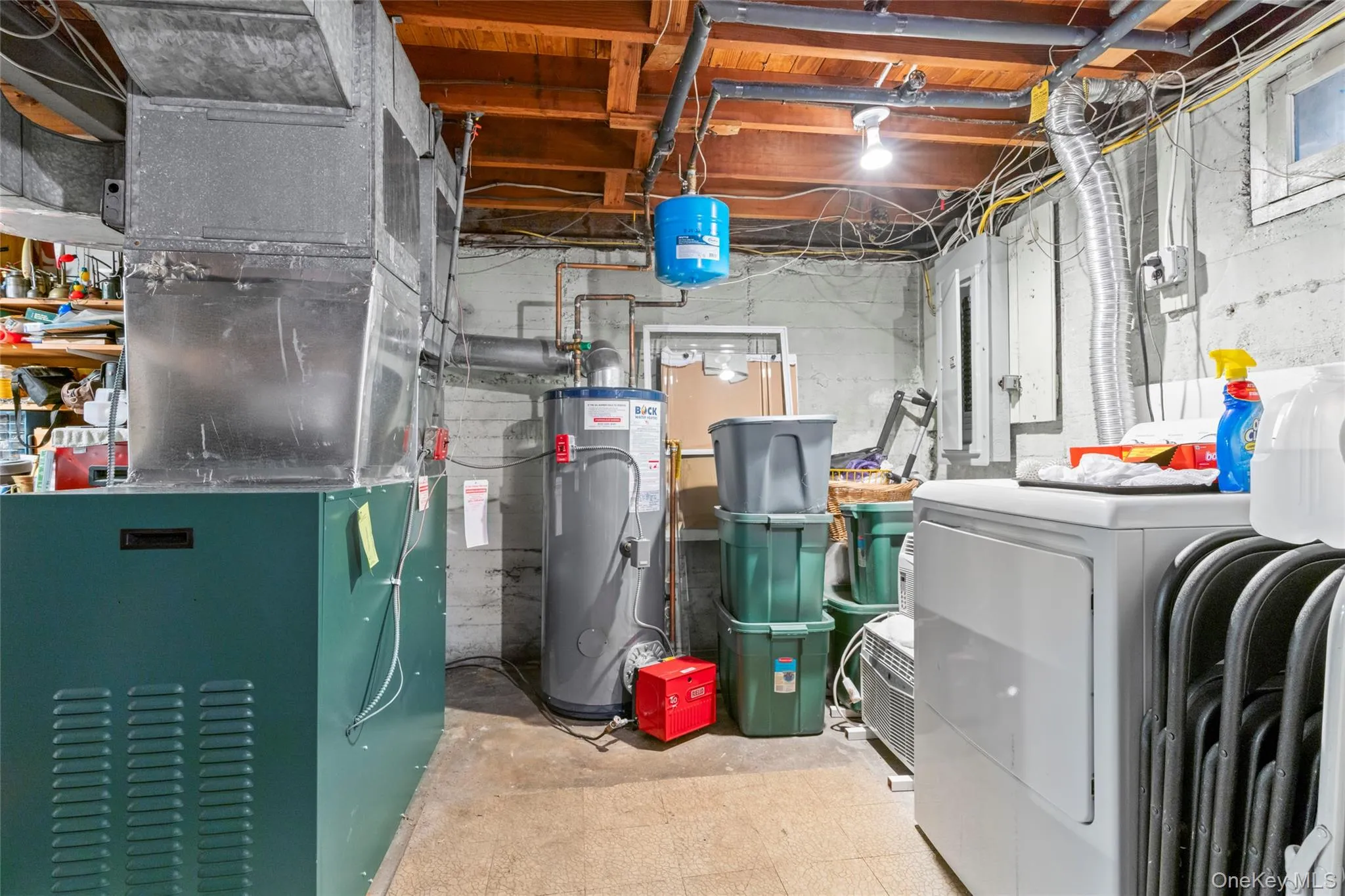 Unfinished basement area featuring heating unit and water heater Unfinished basement area featuring heating unit and water heater