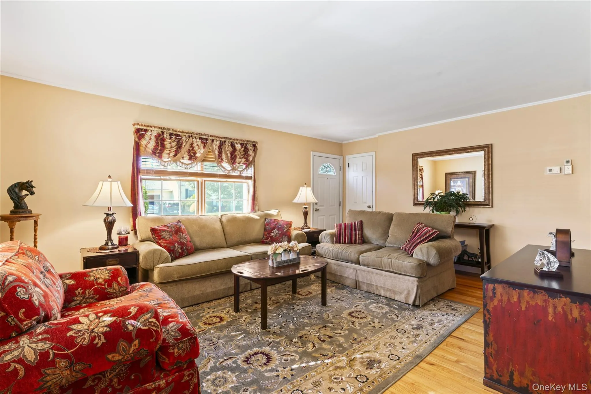 Living area featuring light wood-style flooring and ornamental molding Living area featuring light wood-style flooring and ornamental molding