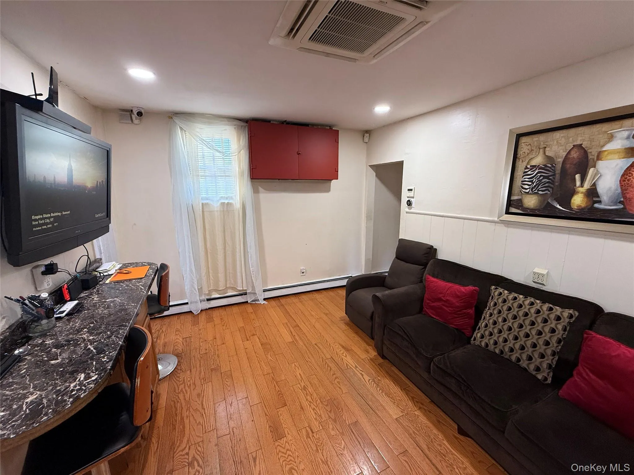 Living room featuring cooling unit, light wood-style floors, recessed lighting, and a baseboard heating unit Living room featuring cooling unit, light wood-style floors, recessed lighting, and a baseboard heating unit