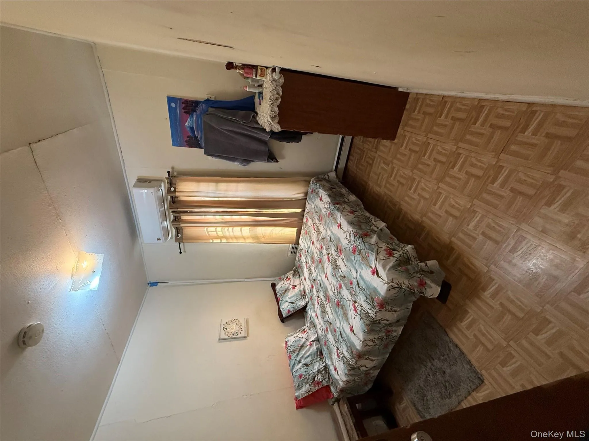 Bedroom featuring a baseboard heating unit and a textured ceiling Bedroom featuring a baseboard heating unit and a textured ceiling