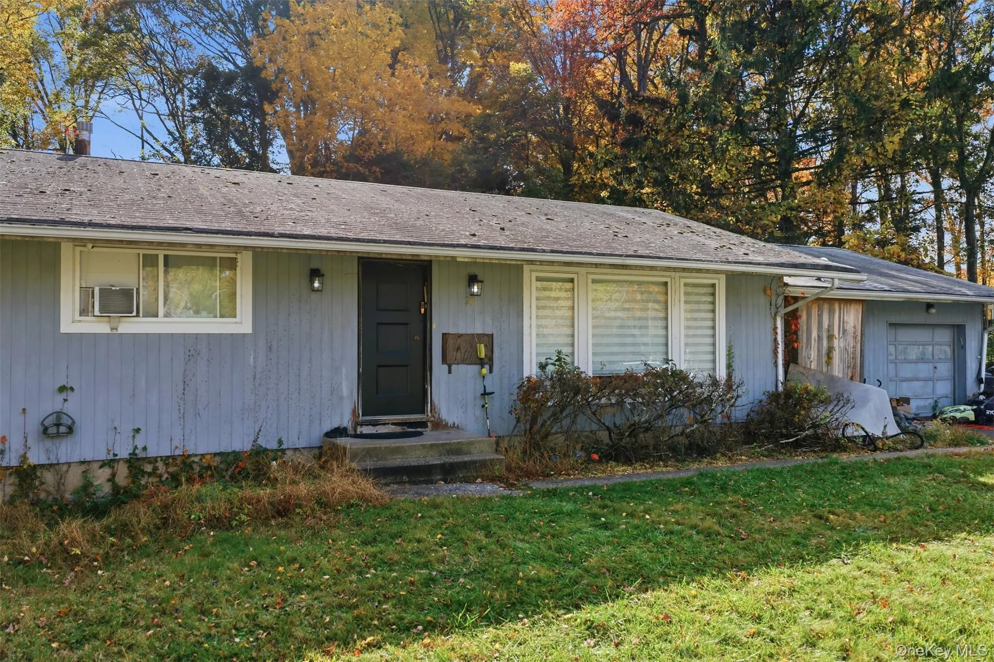 Ranch-style home featuring a front lawn and a garage Ranch-style home featuring a front lawn and a garage