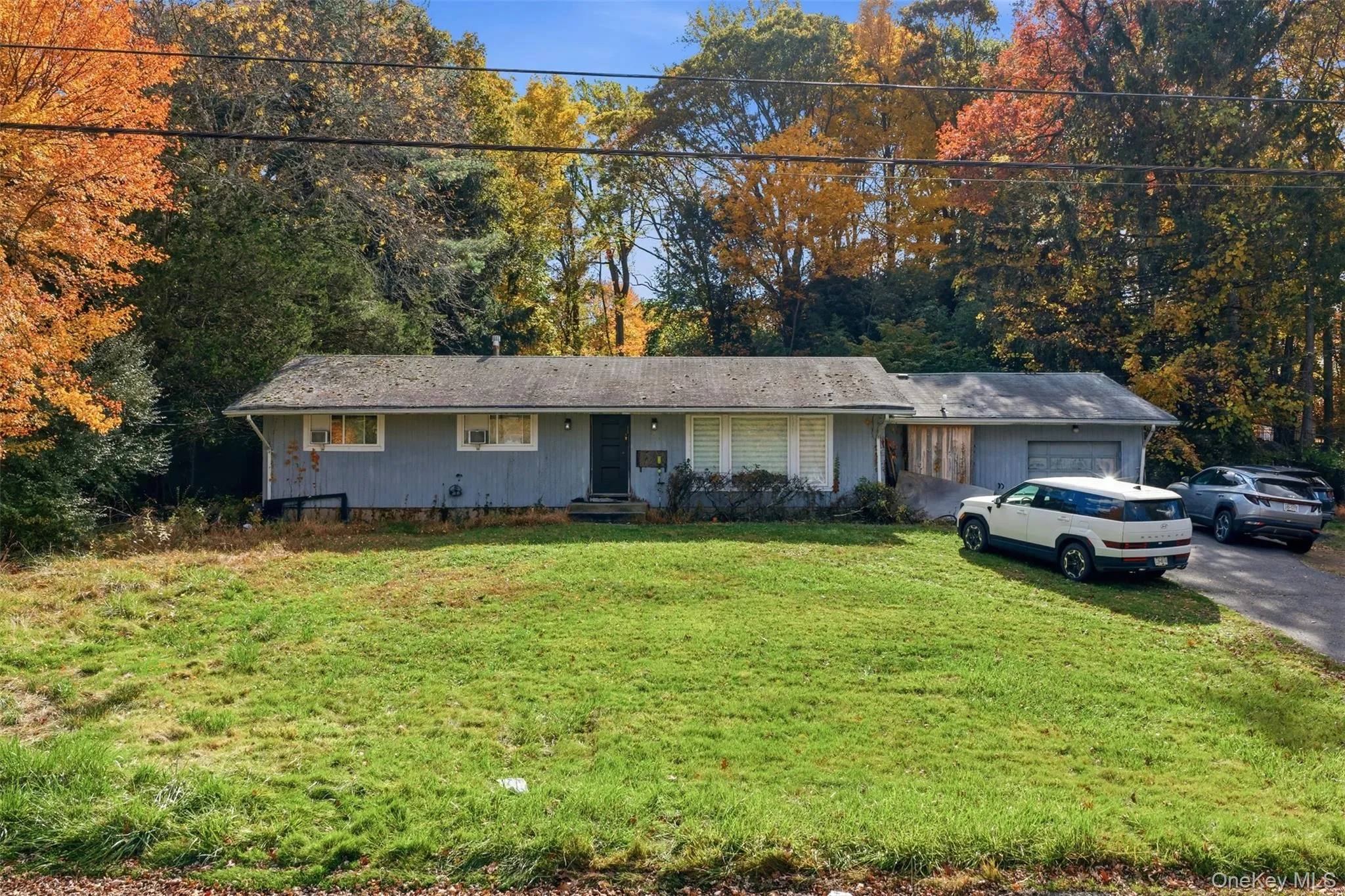 Single story home with a front yard, driveway, and an attached garage Single story home with a front yard, driveway, and an attached garage