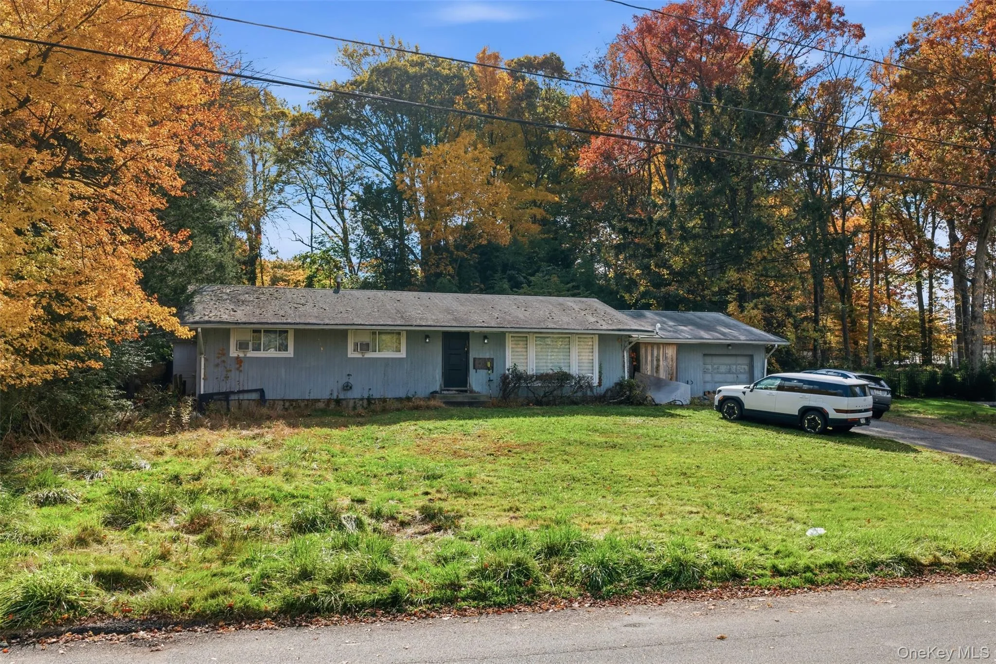 Ranch-style house with an attached garage, a front yard, and driveway Ranch-style house with an attached garage, a front yard, and driveway