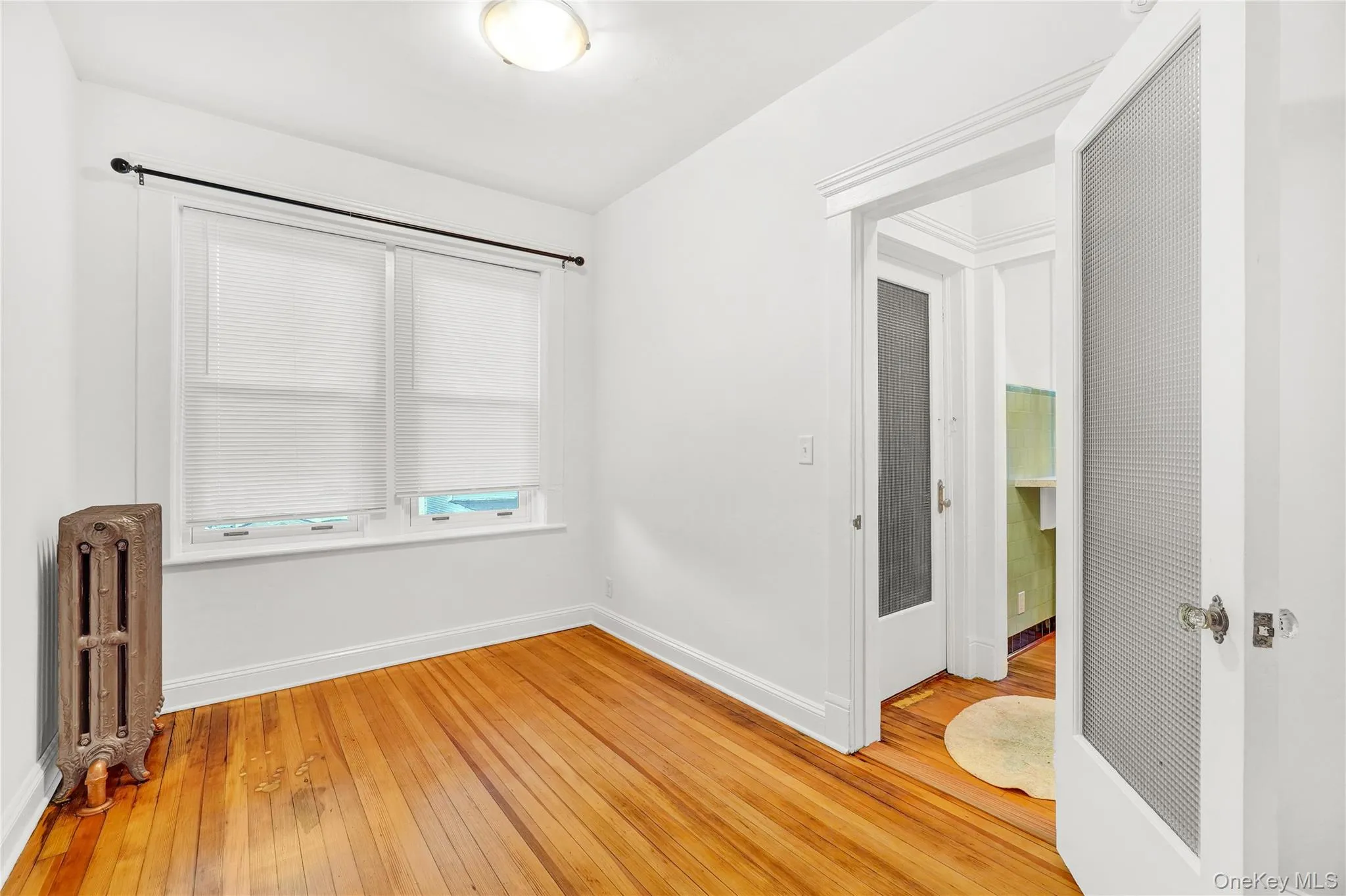 Empty room featuring radiator and light wood finished floors Empty room featuring radiator and light wood finished floors