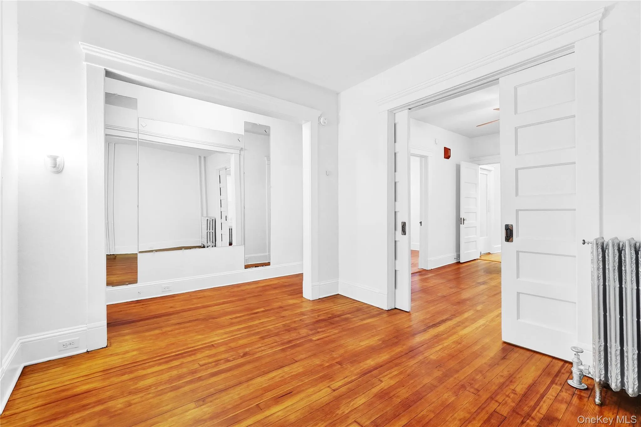 Empty room with radiator and light wood finished floors Empty room with radiator and light wood finished floors