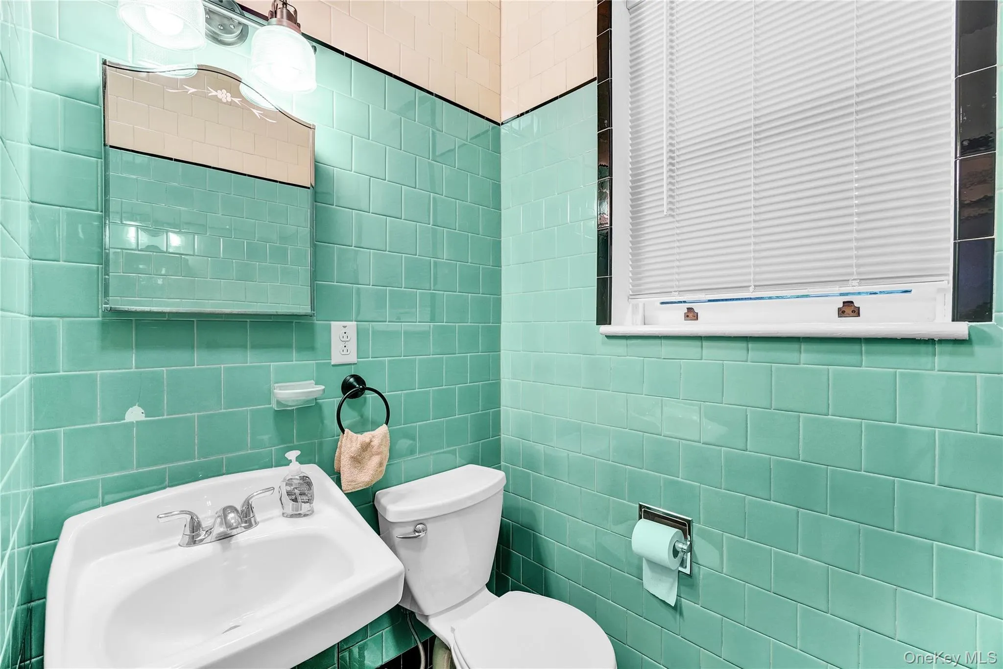 Half bathroom with a sink and tile walls Half bathroom with a sink and tile walls