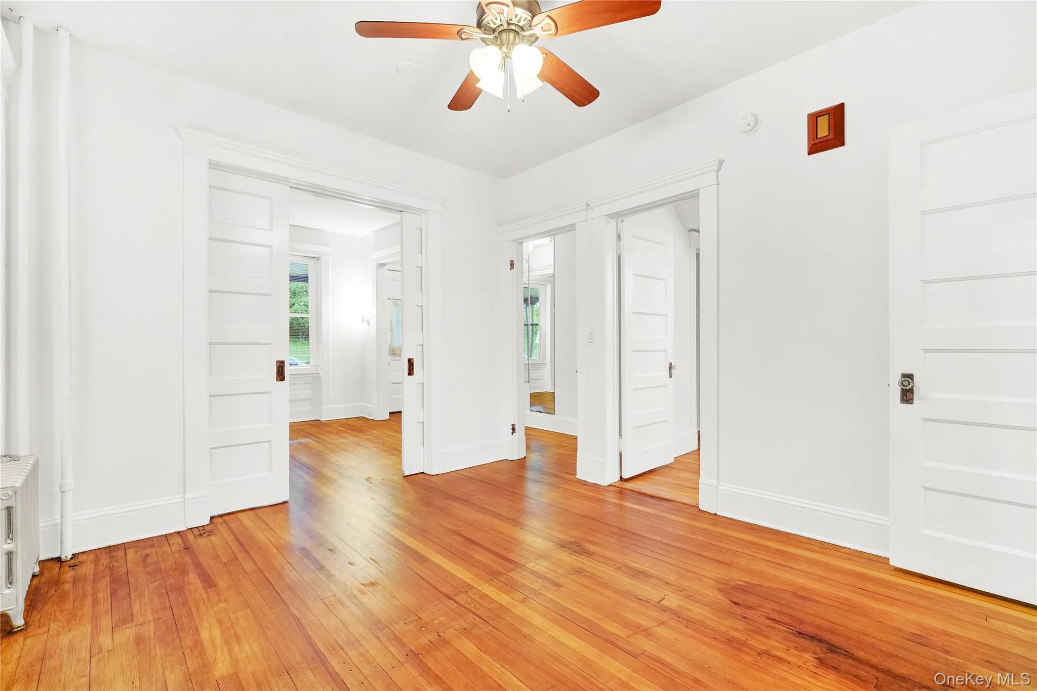 Unfurnished room with light wood-style floors and a ceiling fan Unfurnished room with light wood-style floors and a ceiling fan