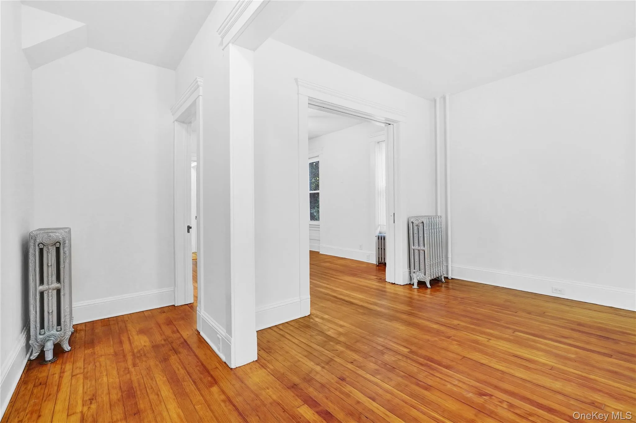 Additional living space with radiator heating unit and light wood finished floors Additional living space with radiator heating unit and light wood finished floors